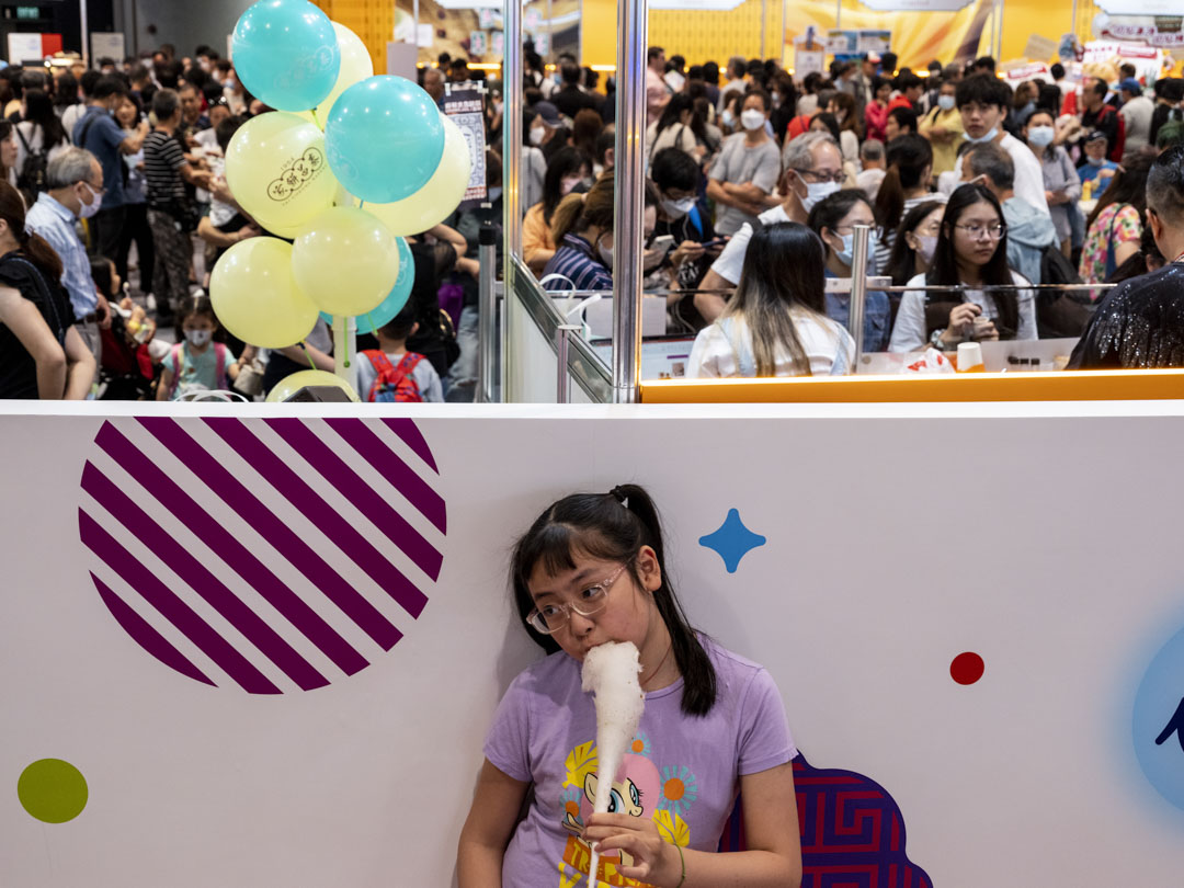 2023年4月30日,「開心香港」美食市集在會展舉行,小朋友在場內進食棉花糖。攝:林振東/端傳媒