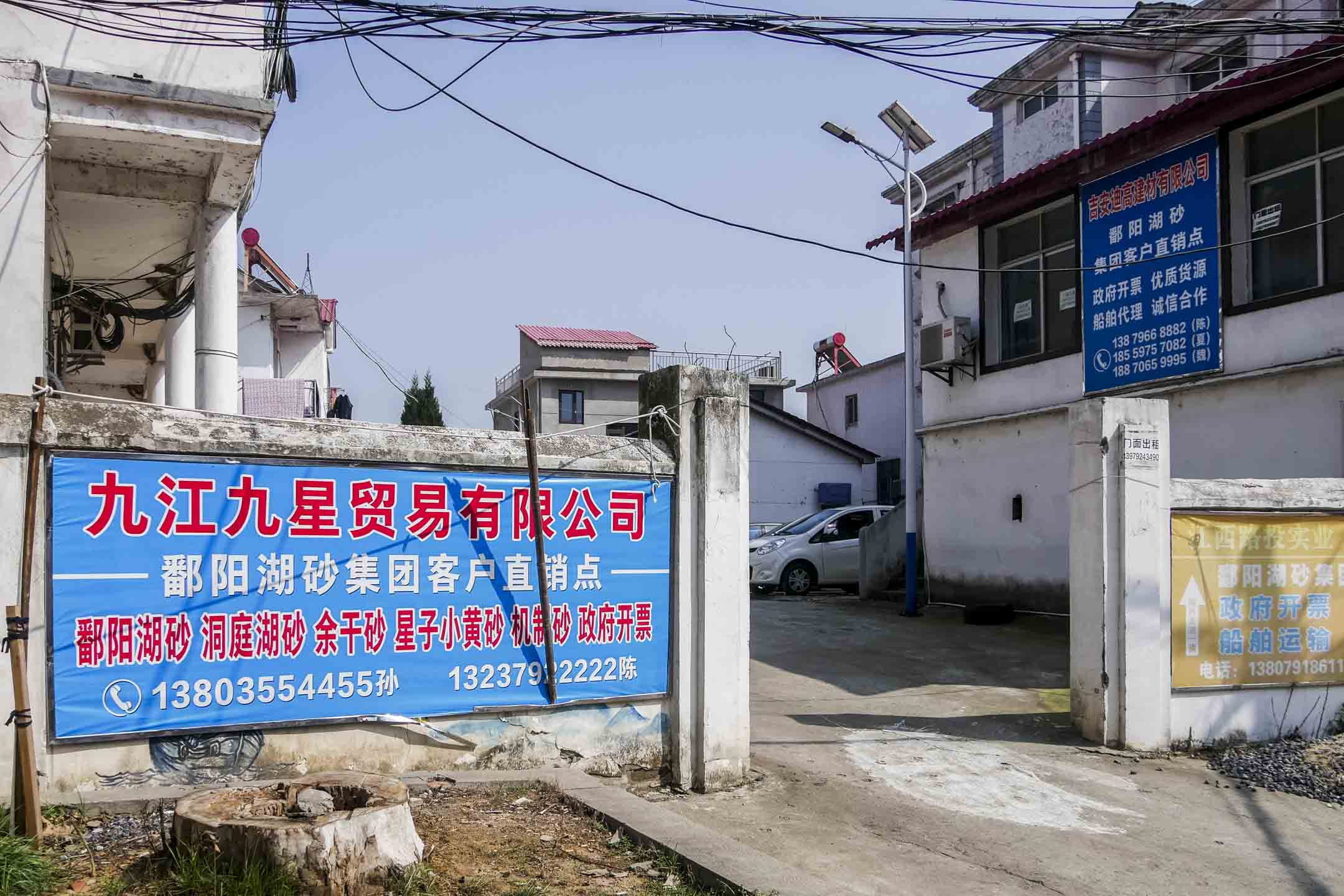 位於鄱陽湖入江口的蛤蟆石漁村,如今遍布著砂石貿易公司的招牌。攝影:Anita Zhang