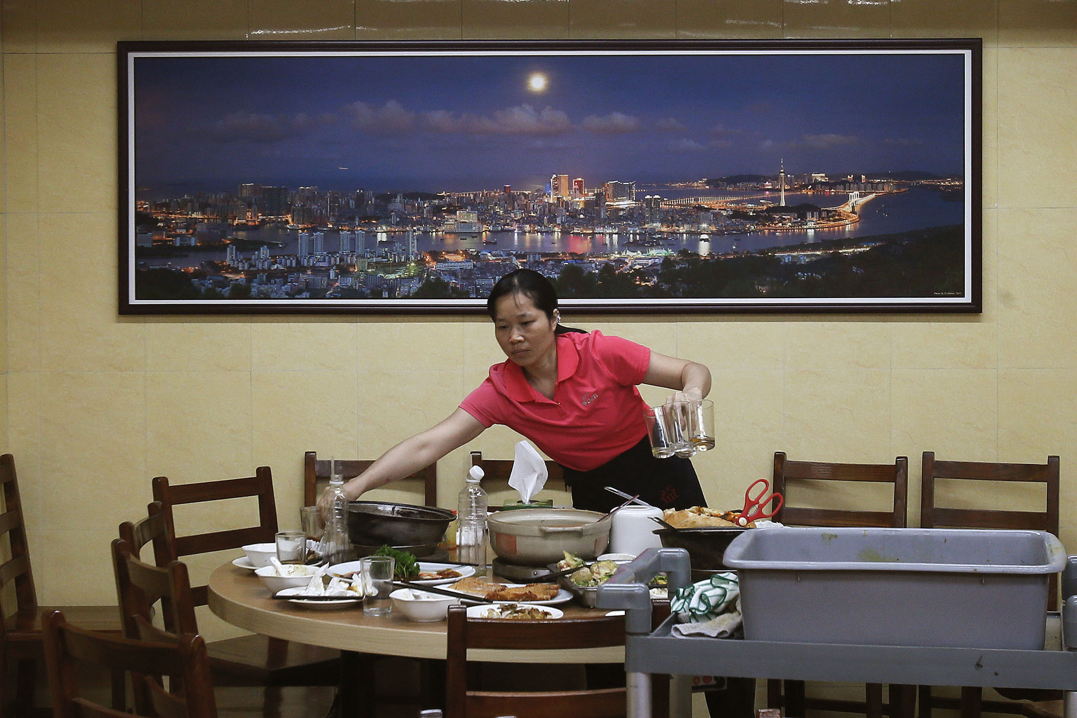 2012年10月10日,澳門,一名工作人員清理餐廳內的桌子。
