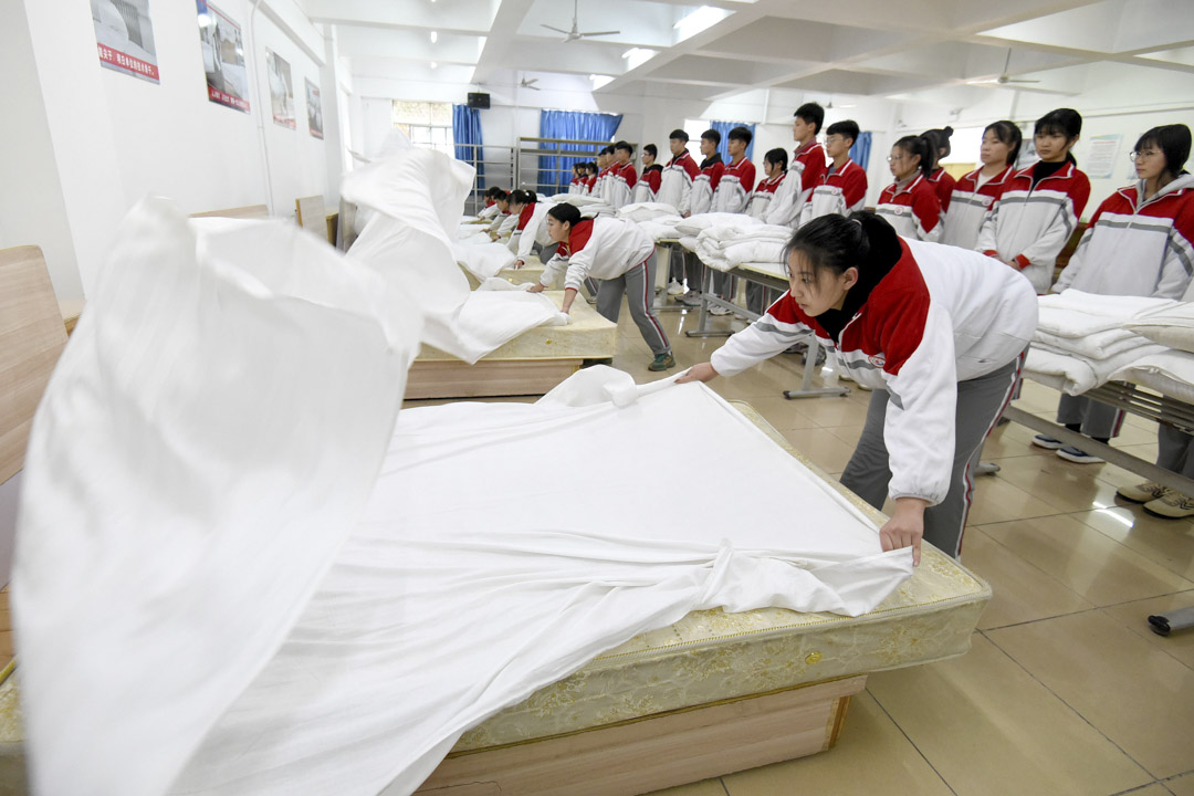 2021年12月9日,河北省邯郸市一所职业学校餐饮实习专业的学生正在学习铺床。摄:HAO QY/Future Publishing via Getty Images