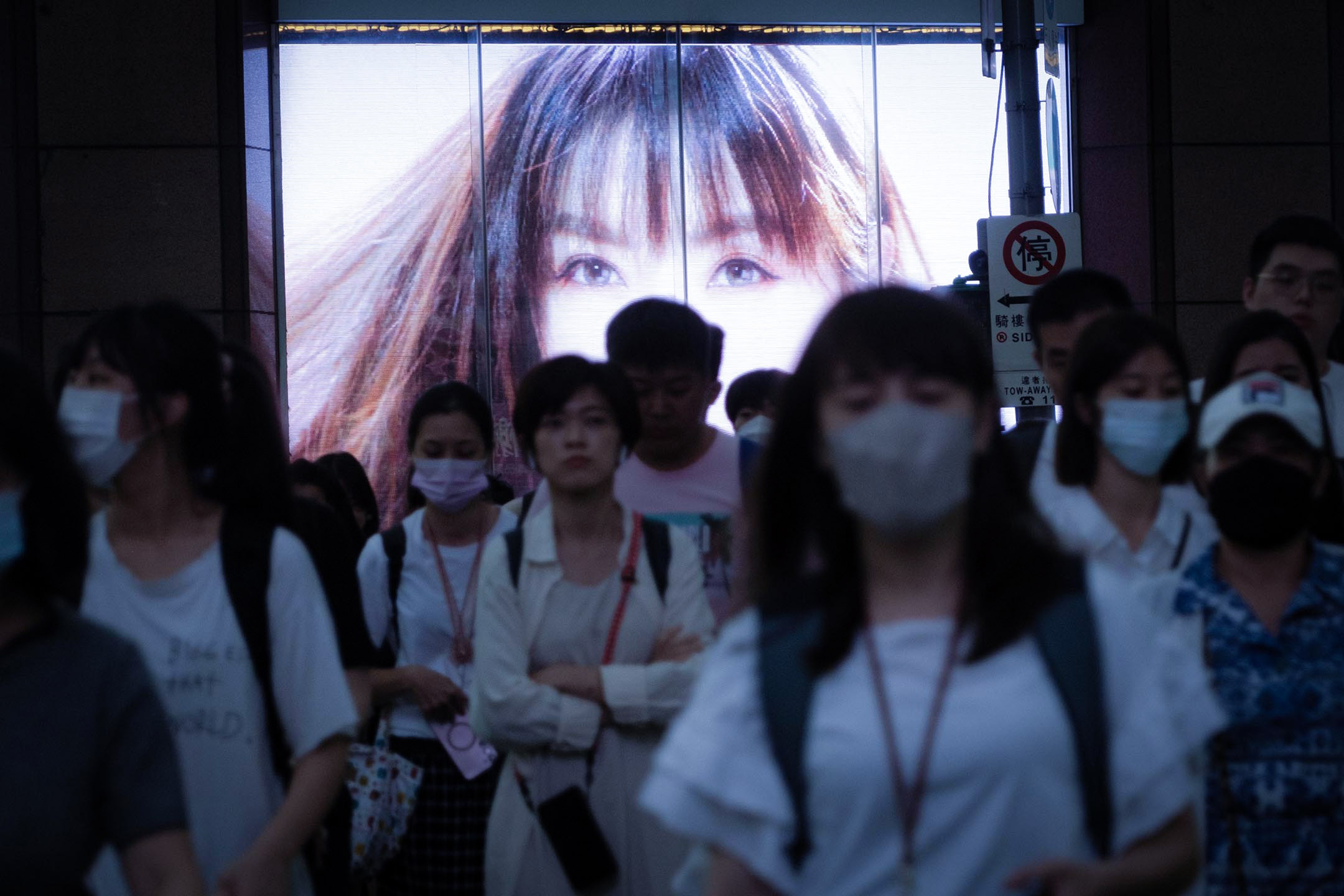 2023年6月9日,台北,行人在广告萤幕前走过马路。摄:陈焯𪸩/端传媒