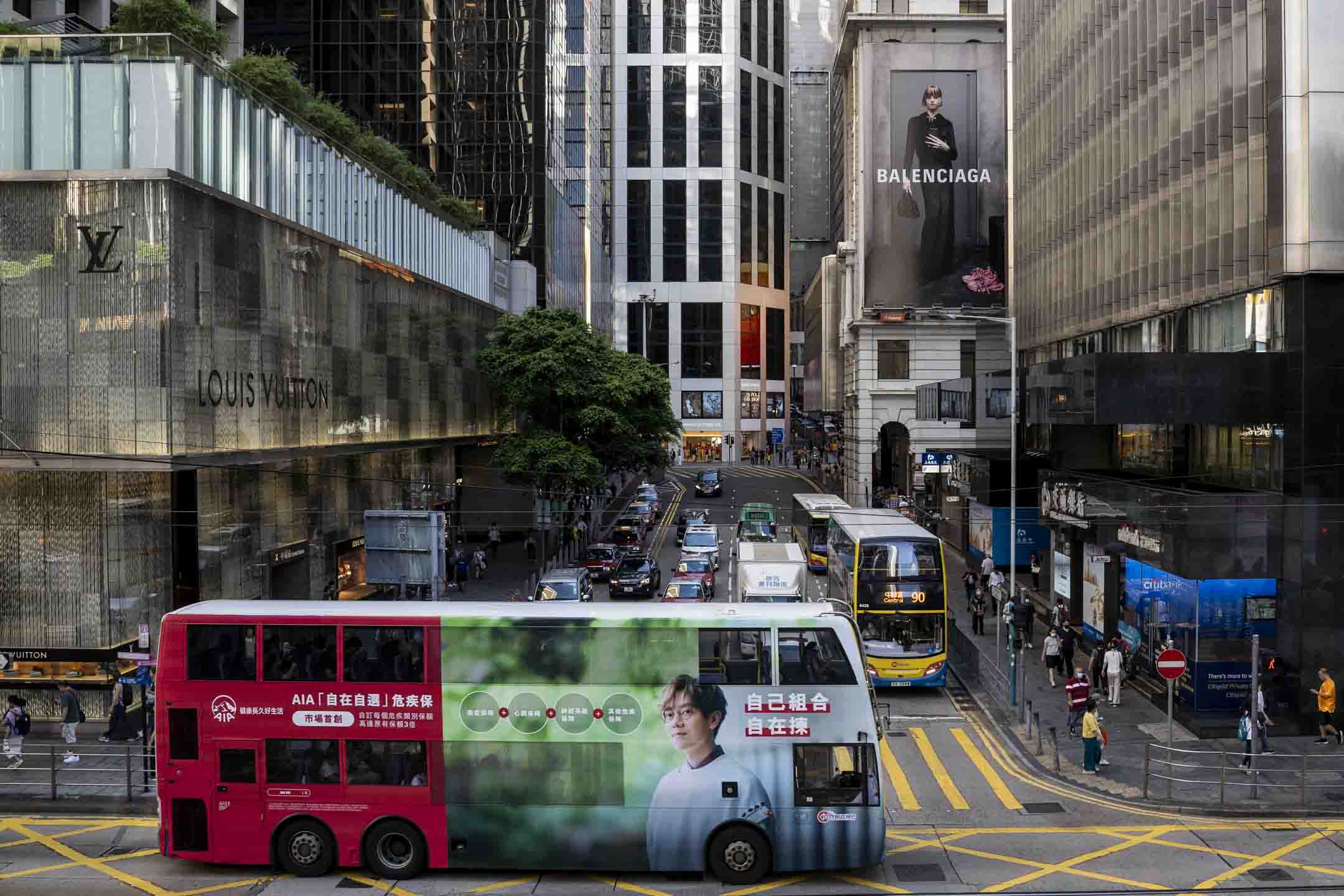 2023年7月12日﹐香港中環,一架車身有保險廣告的巴士在馬路中行駛。攝:林振東/端傳媒