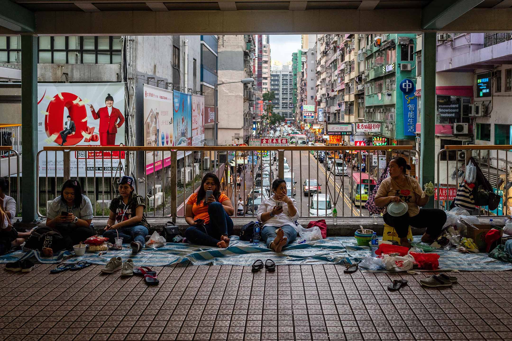 2019年6月22日,香港,外佣坐在旺角行人天桥上。摄:Eduardo Leal/Bloomberg via Getty Images