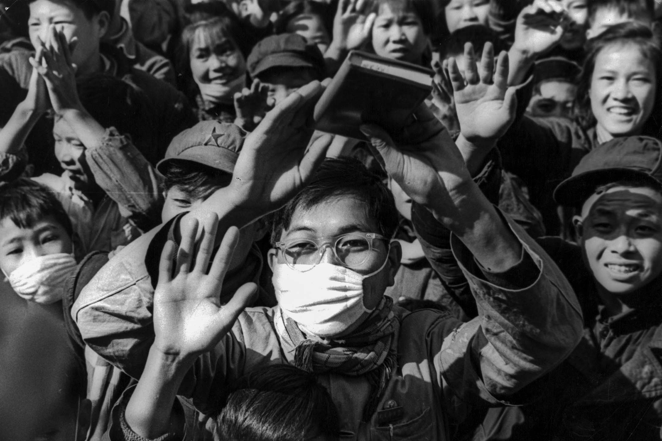 北京，一名戴著口罩的男孩挥舞著他的《毛语录》。图：Getty Images