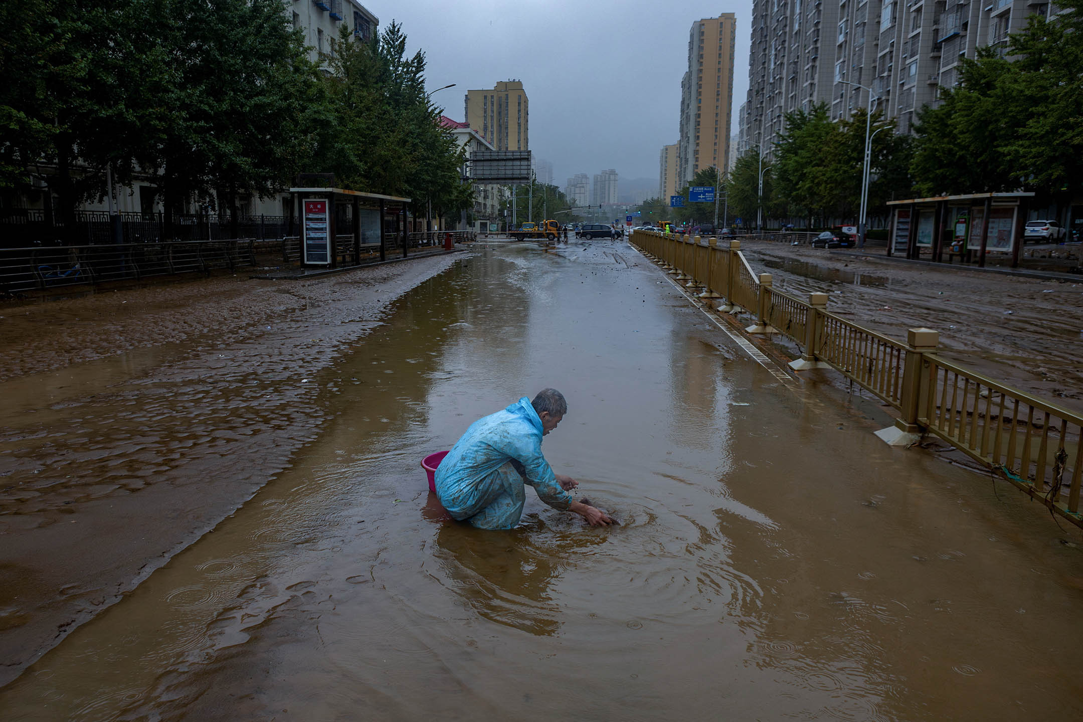 2023年8月1日,北京,一名男子在一条被洪水淹没的街道上。摄:Thomas Peter/Reuters/达志影像
