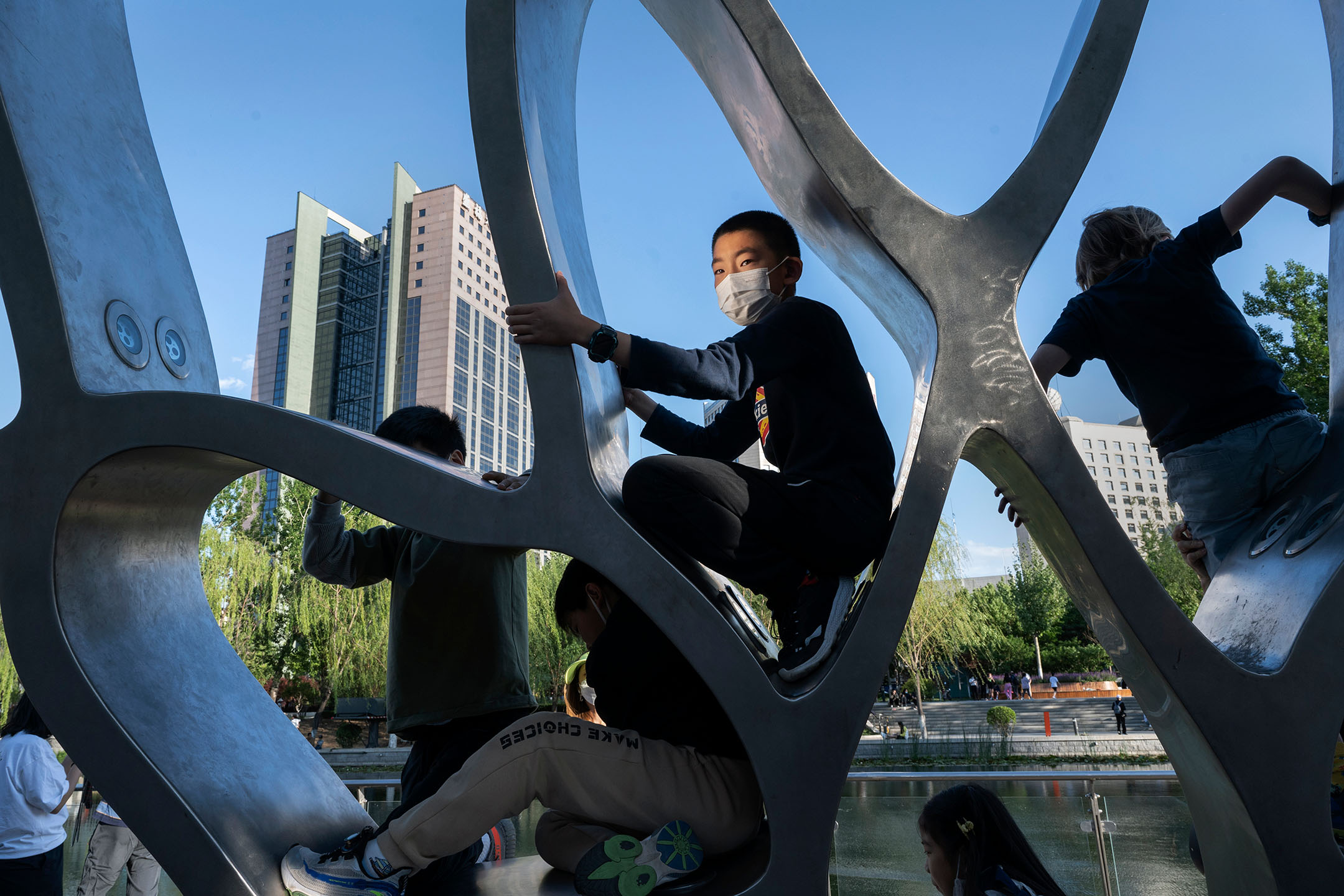 2022年5月14日,中國北京,孩子們在一座雕塑上玩耍。攝:Kevin Frayer/Getty Images