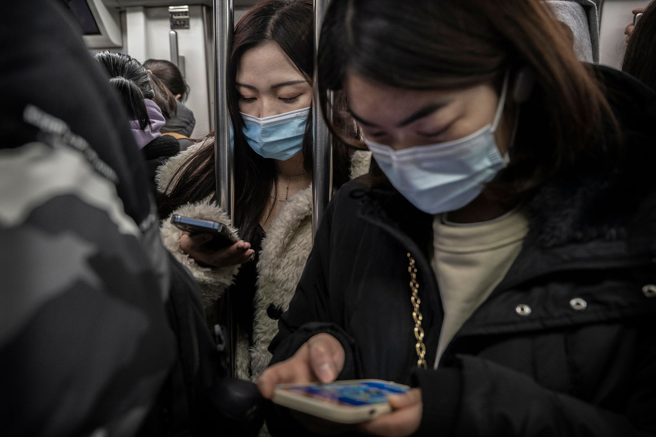 2022年1月13日,中国北京,女士在车厢内看手提电话。摄:Kevin Frayer/Getty Images