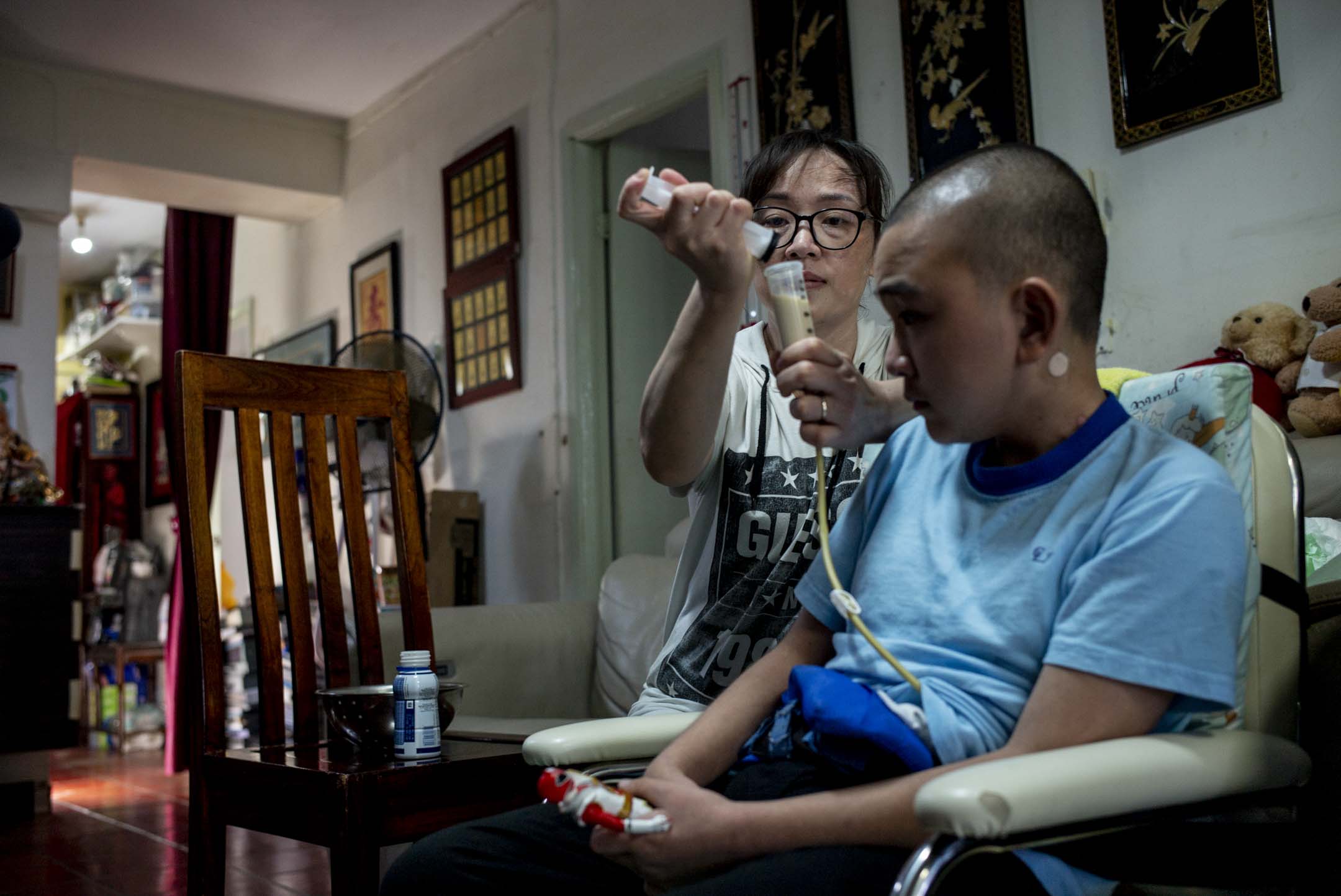 妈妈正在使用导管为家明喂食。摄：林振东/端传媒