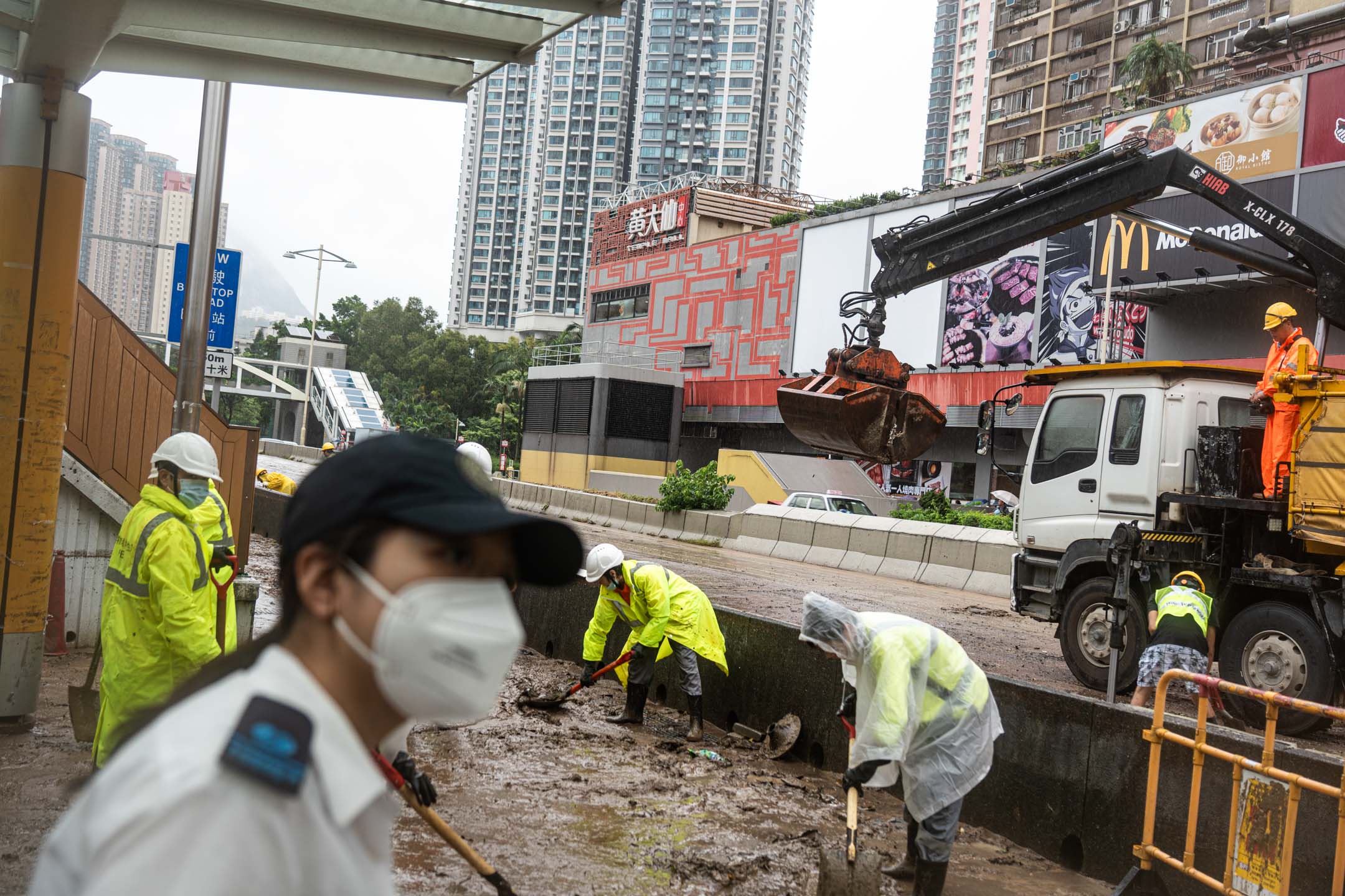 2023年9月8日,大水退后,工人正在清理路面的污泥。摄:Ryan Lai/端传媒