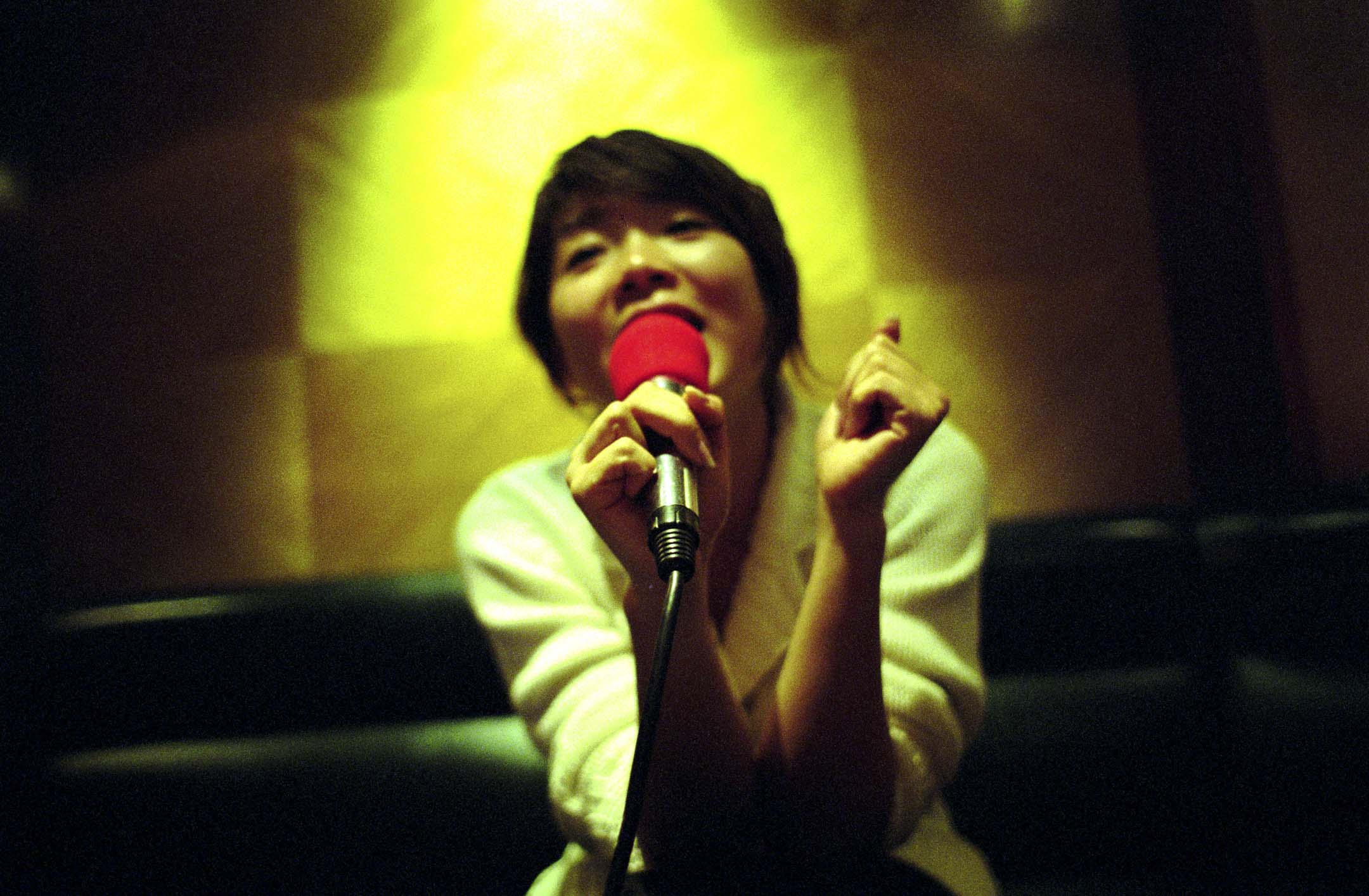 一位女士在卡拉 OK 唱著她最喜欢的歌曲。摄:Ryan Pyle/Corbis via Getty Images