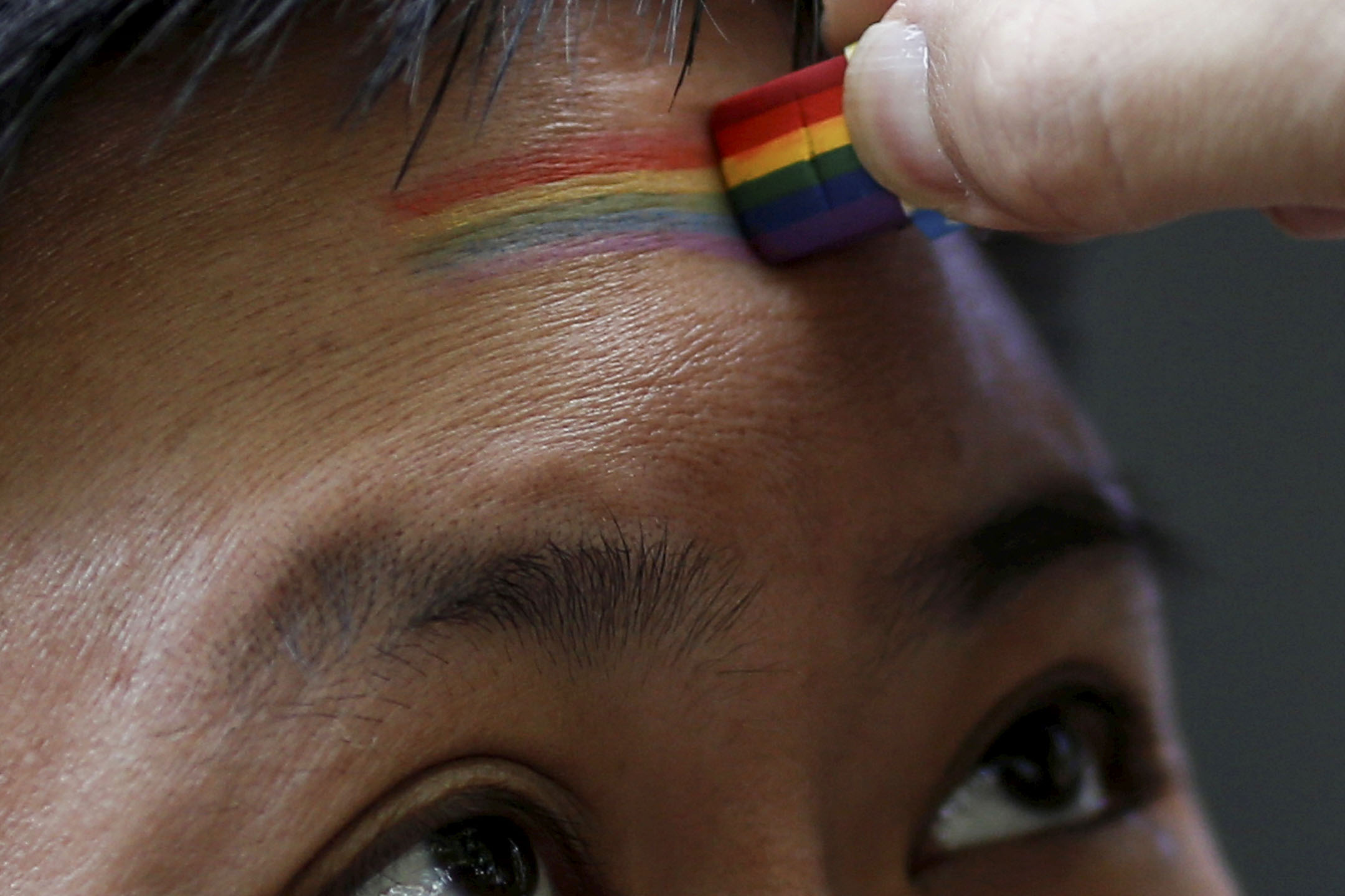 2017年6月17日,上海,一名参与者参加 LGBT活动,在额头上油上了彩虹旗。摄:Aly Song/Reuters/达志影像