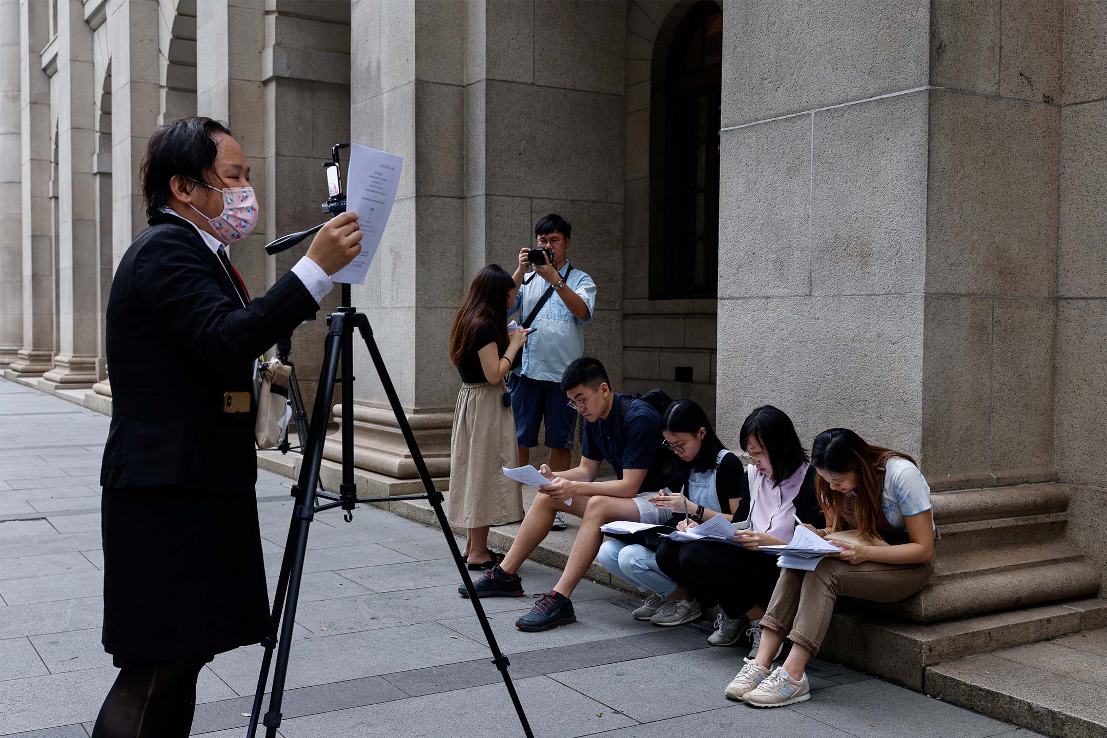 2023年9月5日,記者在終審法院門外閱讀海外同姓婚姻案的判決。攝:Tyrone Siu/Reuters/達志影像