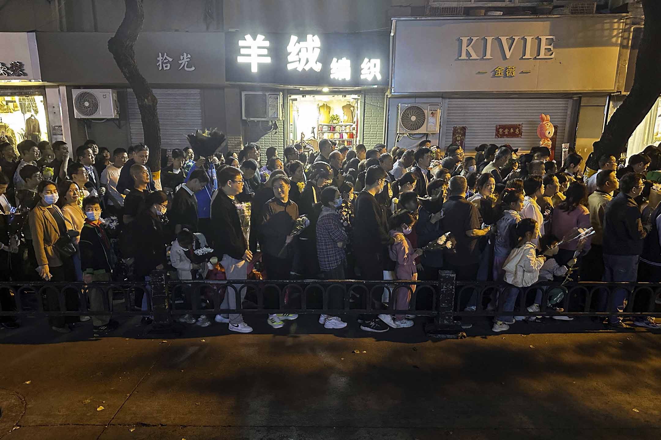 2023年10月28日,安徽省合肥市,人们在中国前总理李克强的故居前排队,为他悼念并献上鲜花。摄:The Yomiuri Shimbun/AP/达志影像