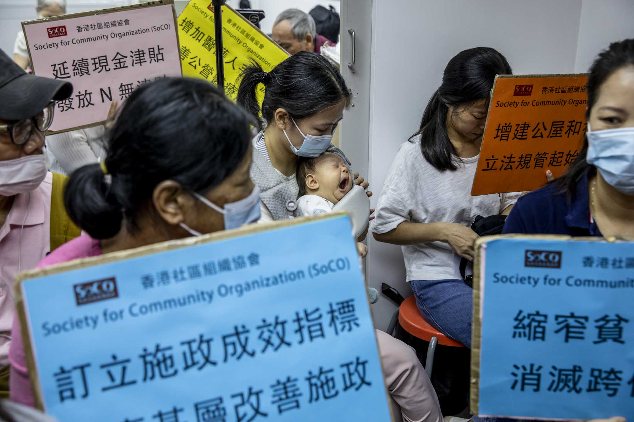 2023年10月25日,香港社協安排基層市民一同收看行政長官宣讀本年度的施政報告,其中有市民帶同嬰孩來觀看。攝:林振東/端傳媒