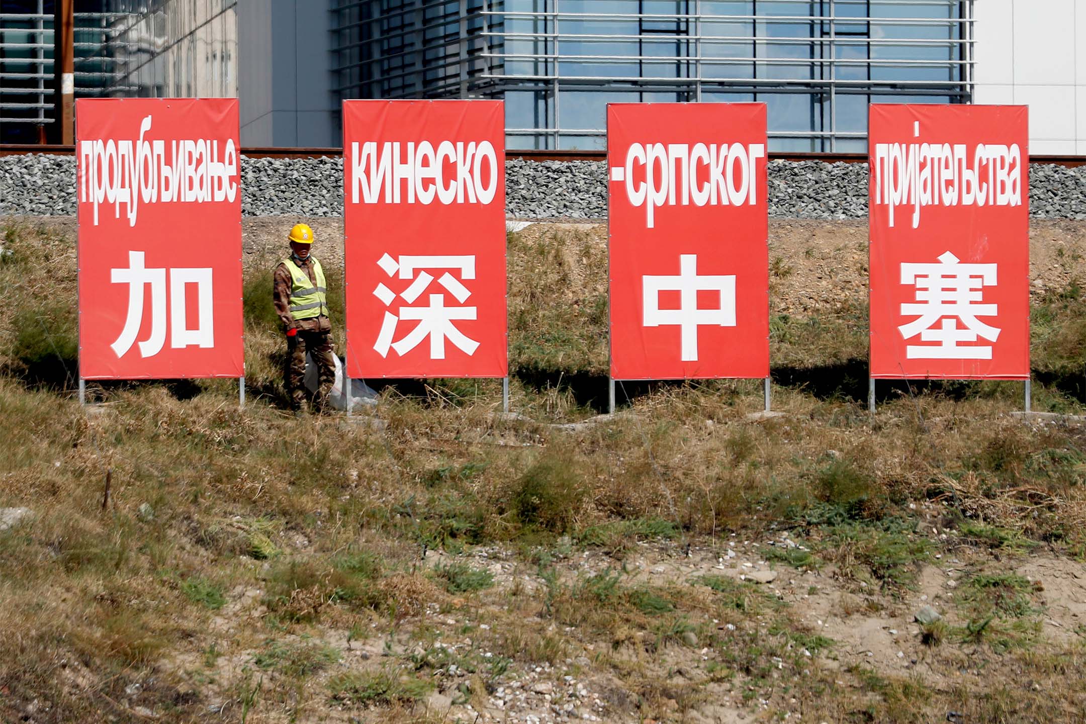 2020年9月14日,一名工人站在鐵路上的「加強中塞」的廣告板旁。攝:Darko Vojinovic/AP/達志影像
