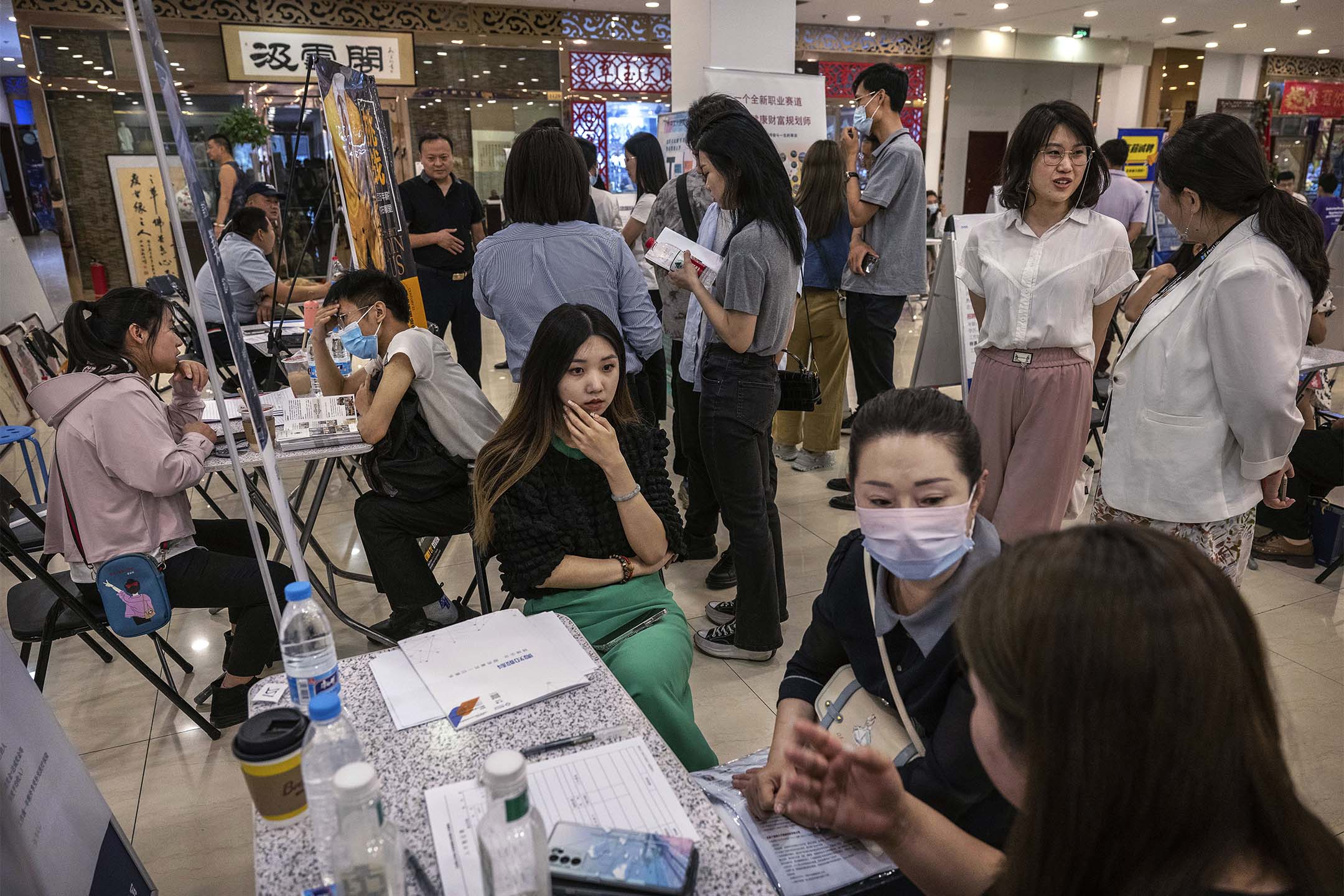 2023年6月9日,北京举行的招聘会上,求职者和招募人员交谈。摄:Kevin Frayer/Getty Images