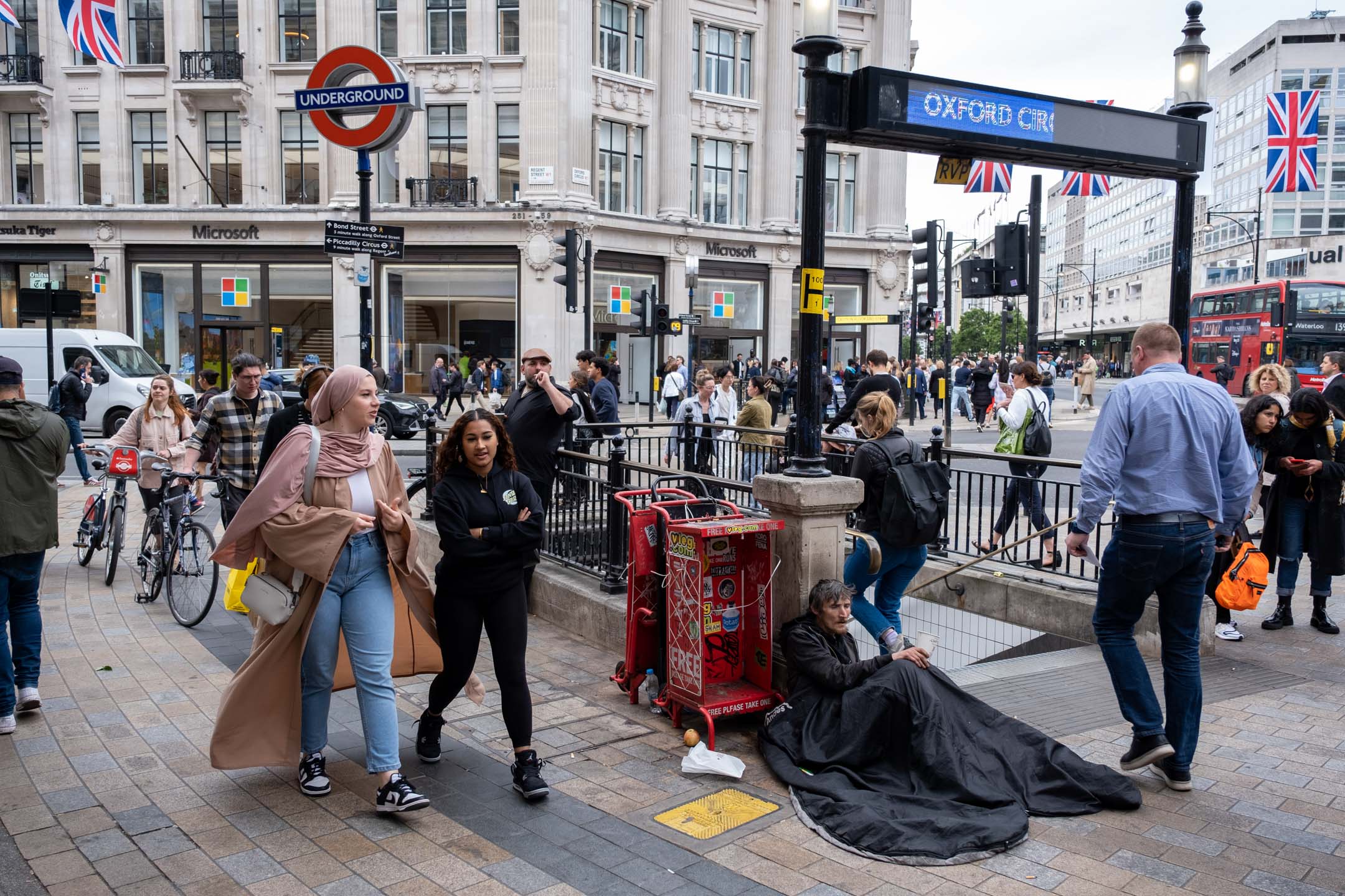 2023年5月22日,英國倫敦,市民和遊客在一名無家者身旁經過。攝:Mike Kemp/In Pictures via Getty Images