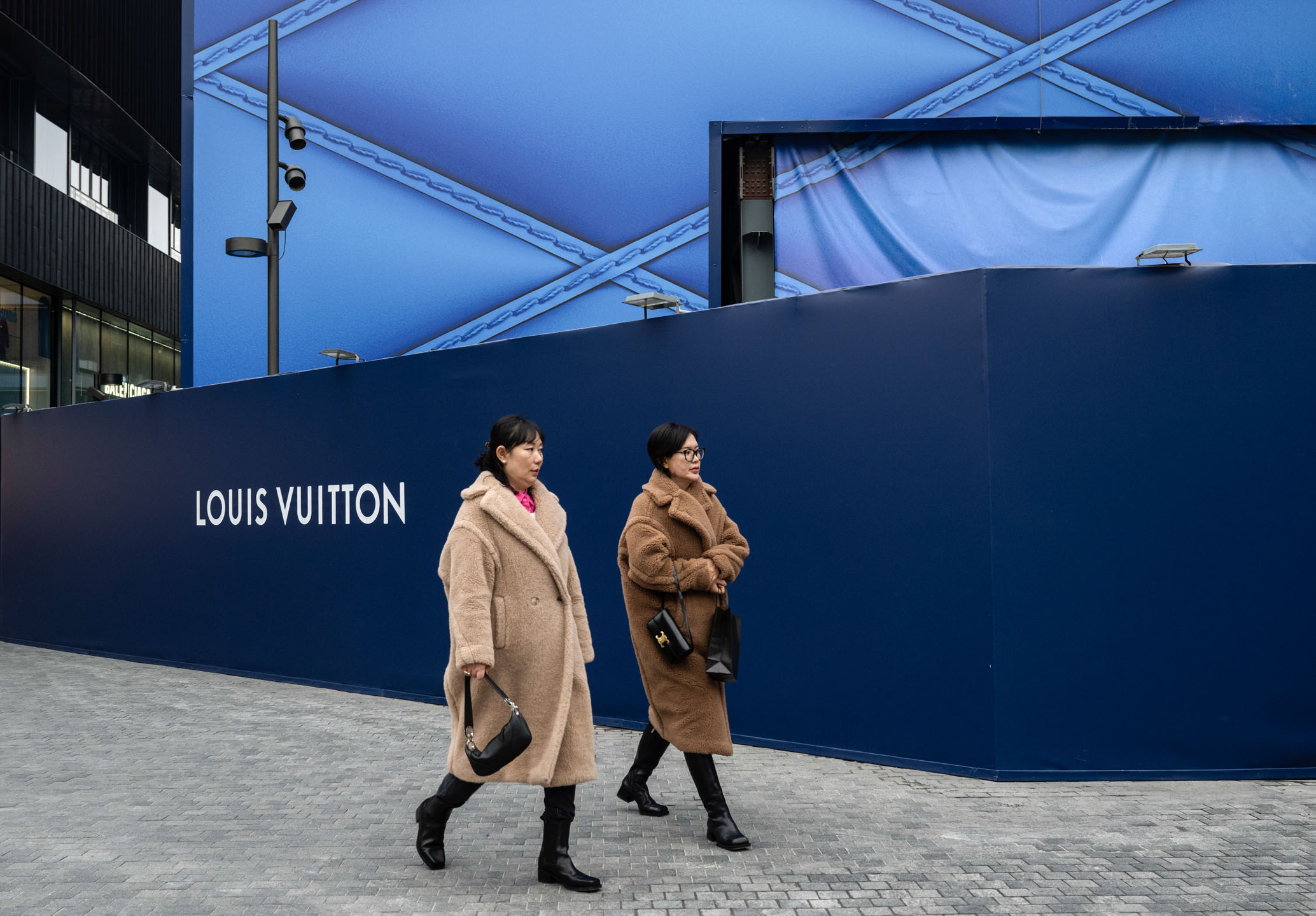 2023年11月15日,中国北京,市民经过奢侈品牌Louis Vuitton的零售店。摄:Kevin Frayer/Getty Images