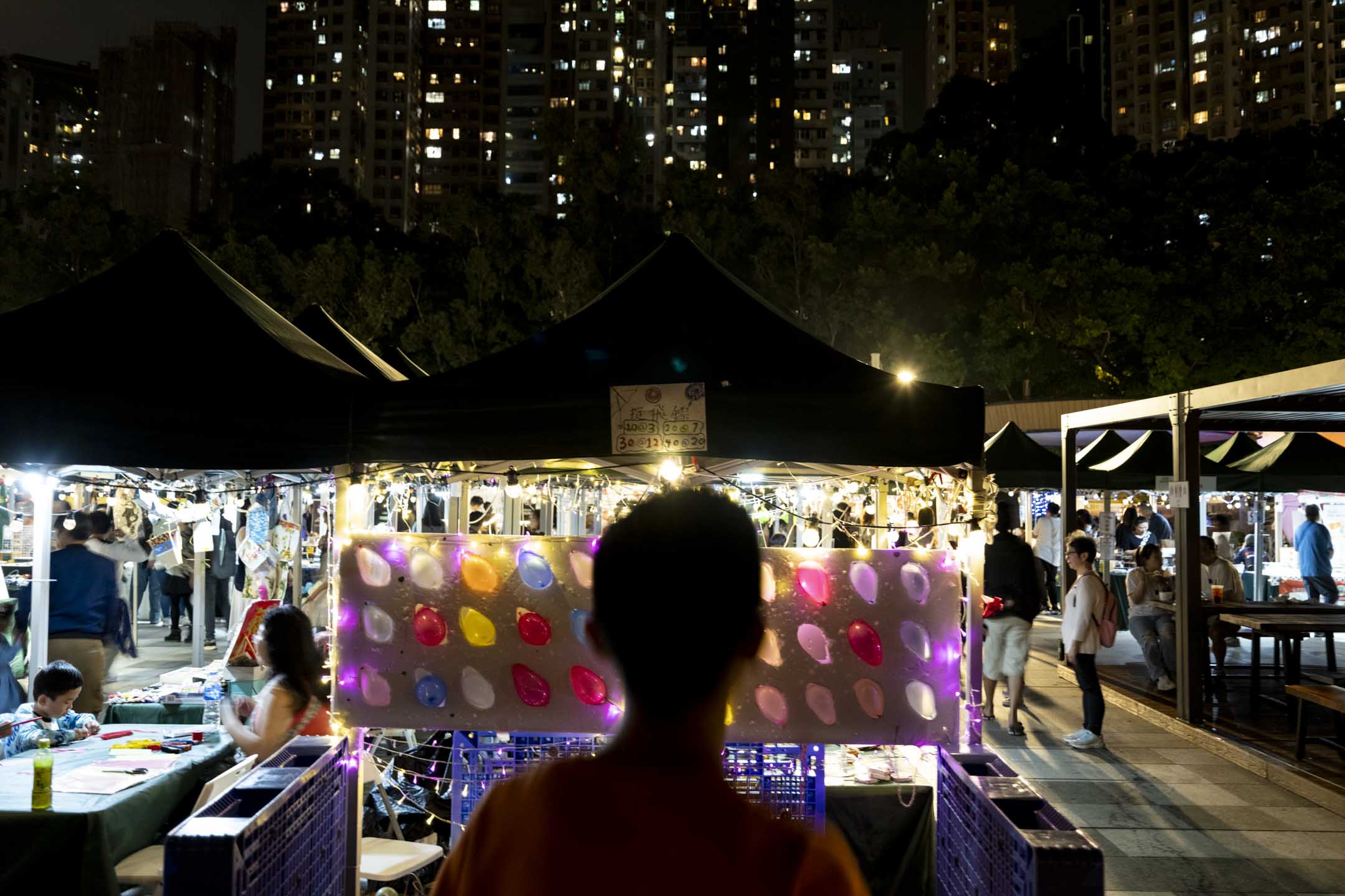香港一名少年站在夜市中。攝:林振東/端傳媒