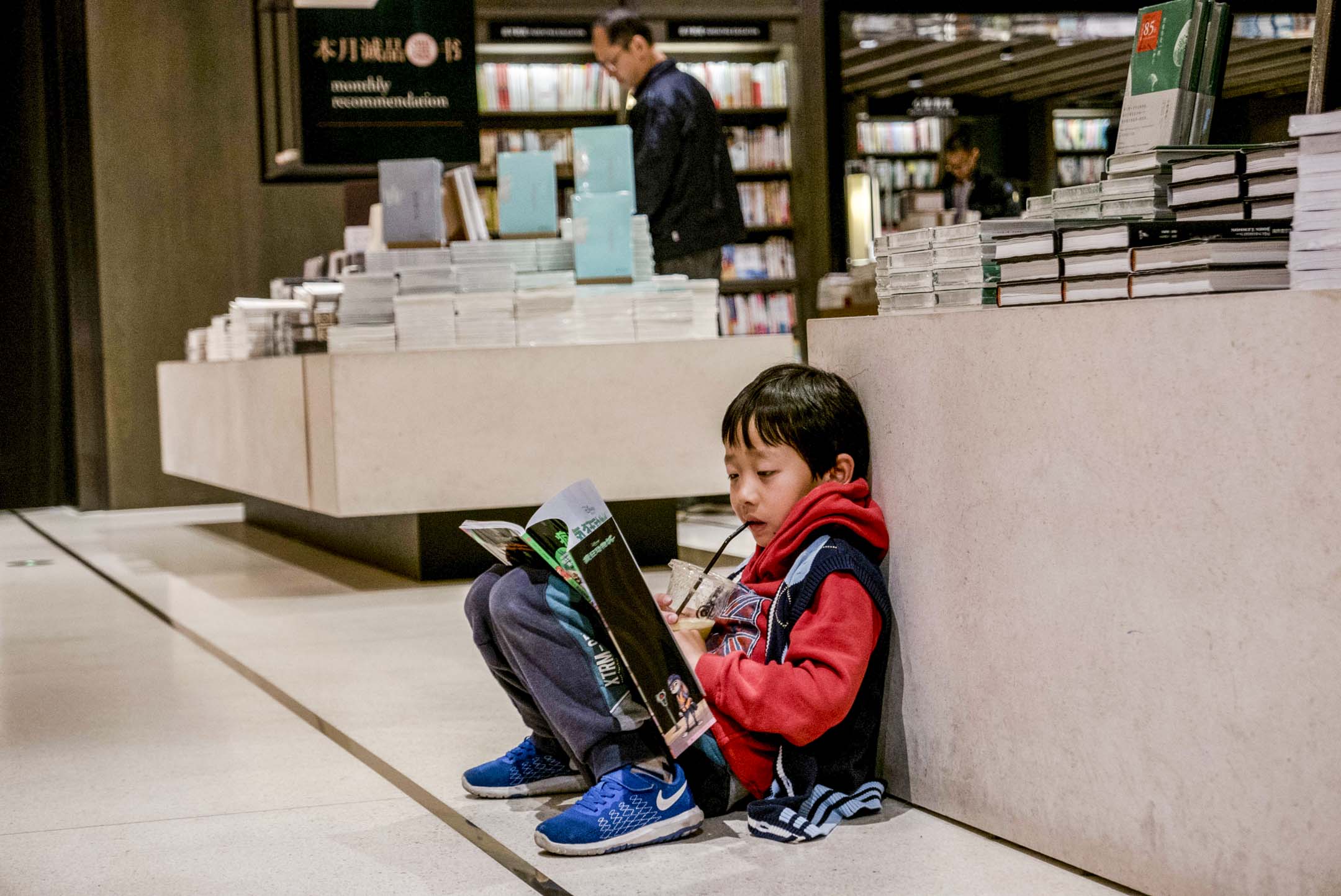 中国苏州一个小男孩坐在诚品书店的地板上读书。摄:Zhang Peng/LightRocket via Getty Images