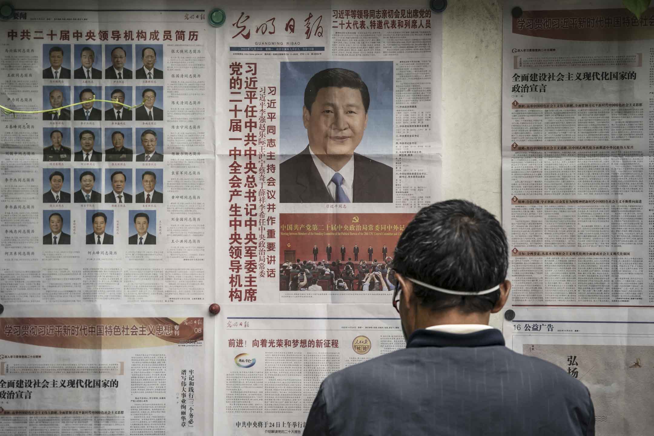 2022年10月26日,中國上海,居民們正在閱讀刊登中國國家主席習近平的報章。攝:Qilai Shen/Bloomberg via Getty Images