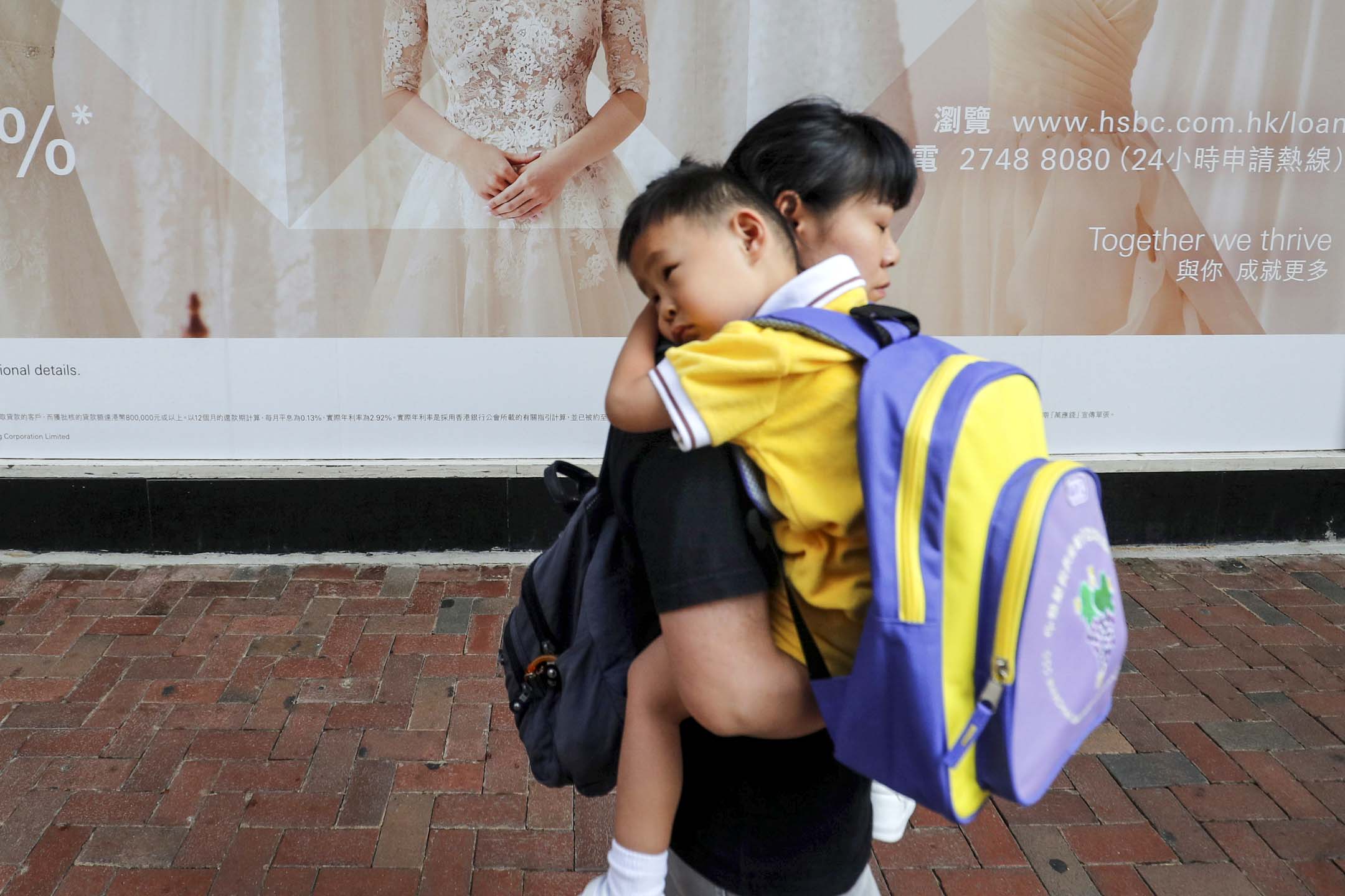 香港一位母亲抱著孩子上学。摄:Amr Abdallah Dalsh/Reuters/达志影像
