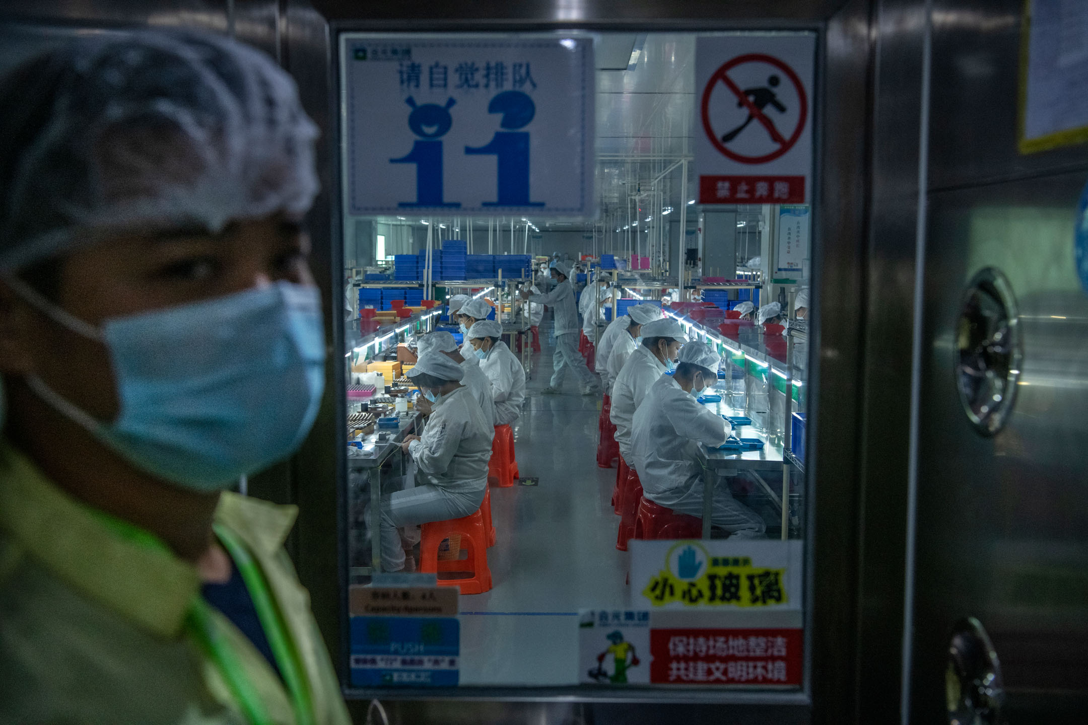 2019年9月25日,中国深圳,工人们在电子烟制作工厂工作。摄:Kevin Frayer/Getty Images