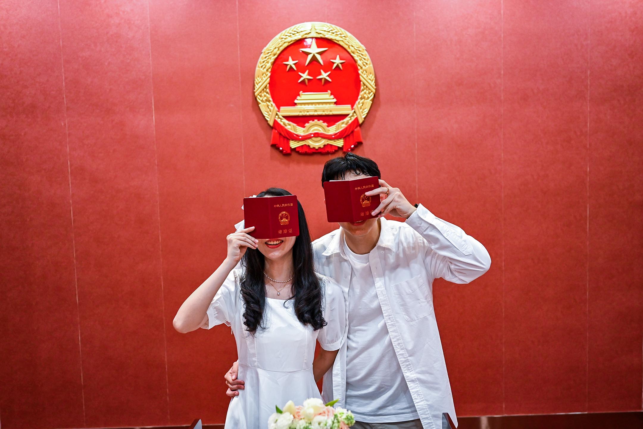 2023年5月20日,一對新婚夫婦在中國福建省泉州婚姻登記中心拿著結婚證書擺拍。攝:Xie Mingfei/VCG via Getty Images