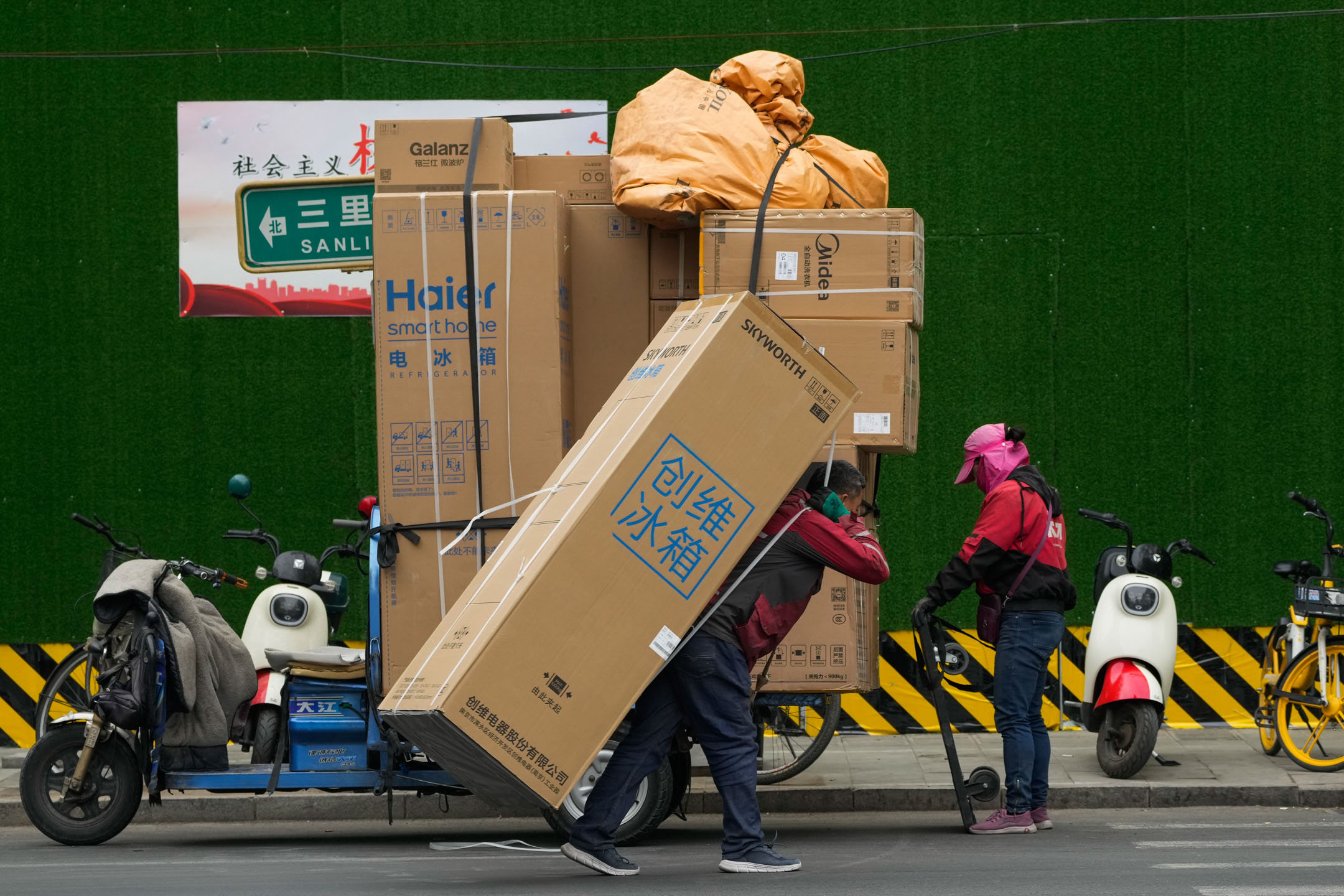 2023年4月27日,中國北京,一名送貨員正在為顧客運送貨品。攝:Andy Wong/AP/達志影像