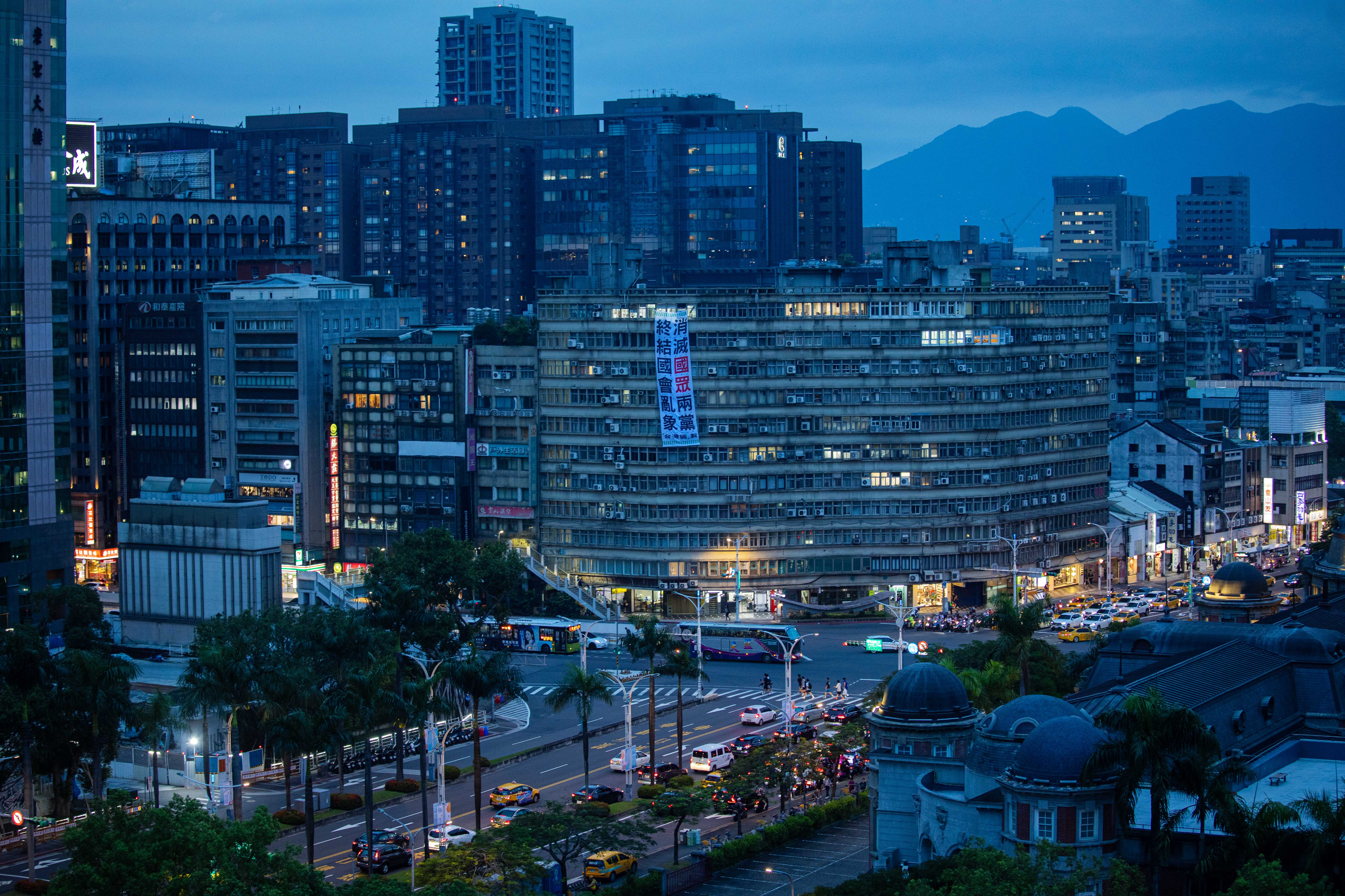 2024年6月20日,台北,立法院外一幢大厦外挂上反对国民党和民众党的布条。摄:陈焯煇/端传媒