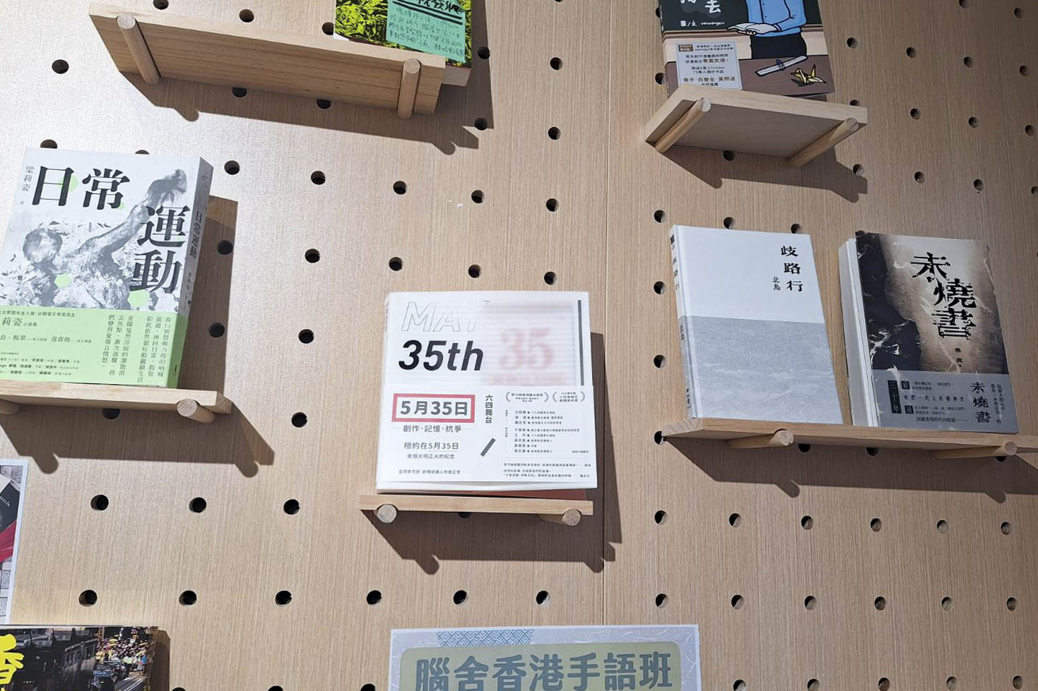 六四前夕,有警察到前民主派区议员黄文萱开设的猎人书店,登记出入人士身份证。2024年6月4日,书店门前红色的“35/5”字样依旧。书墙上,香港剧作家庄梅岩创作的舞台剧《5月35日》放在置中位置。
