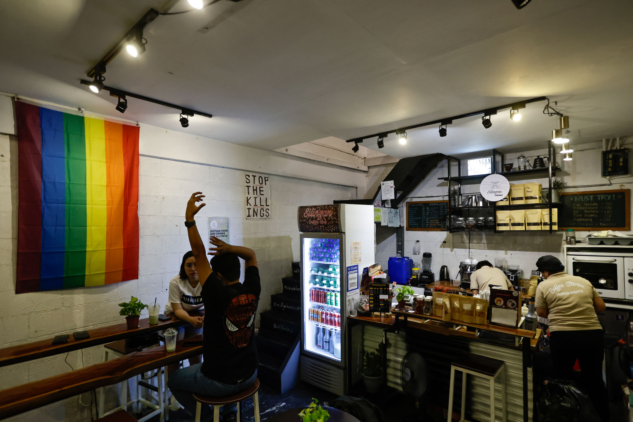 Silingan Coffee格局方正,面積不大,與隔壁一家文青咖啡店風格迴異,裝潢更平實簡單,只有一個開放式廚房、一張吧枱和數張木椅桌。攝:Daniel Ceng/端傳媒