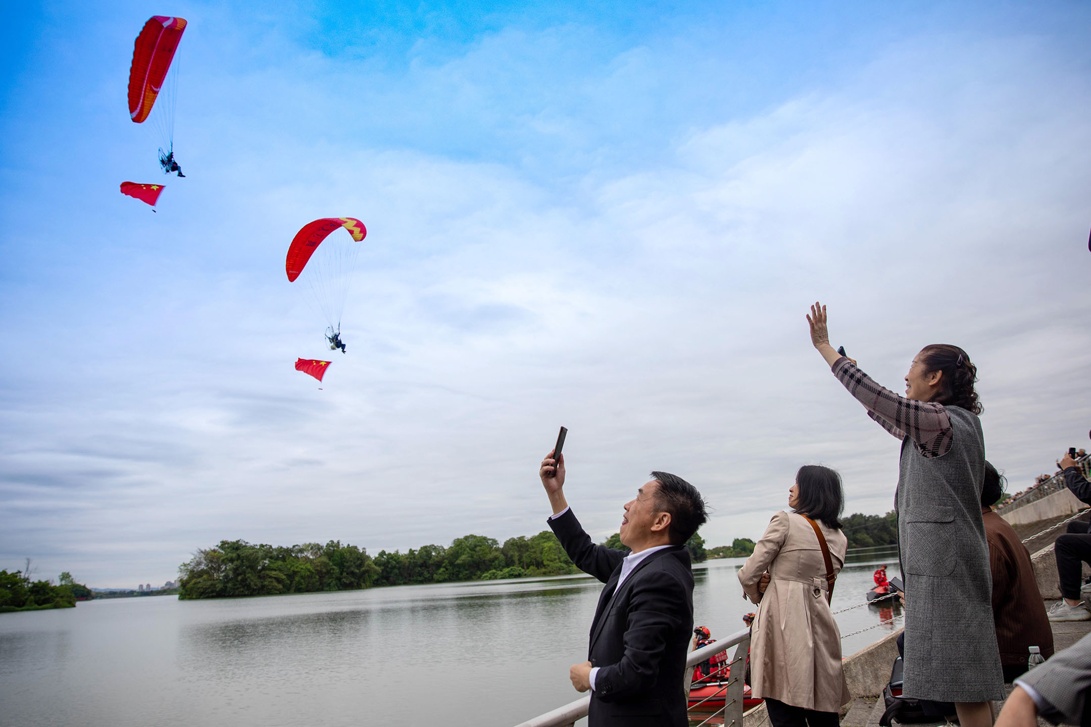 2024年4月30日,中國重慶舉行低空飛行消費周,人們在龍水湖附近觀賞低空飛行表演。攝:Huang Shu/VCG via Getty Images