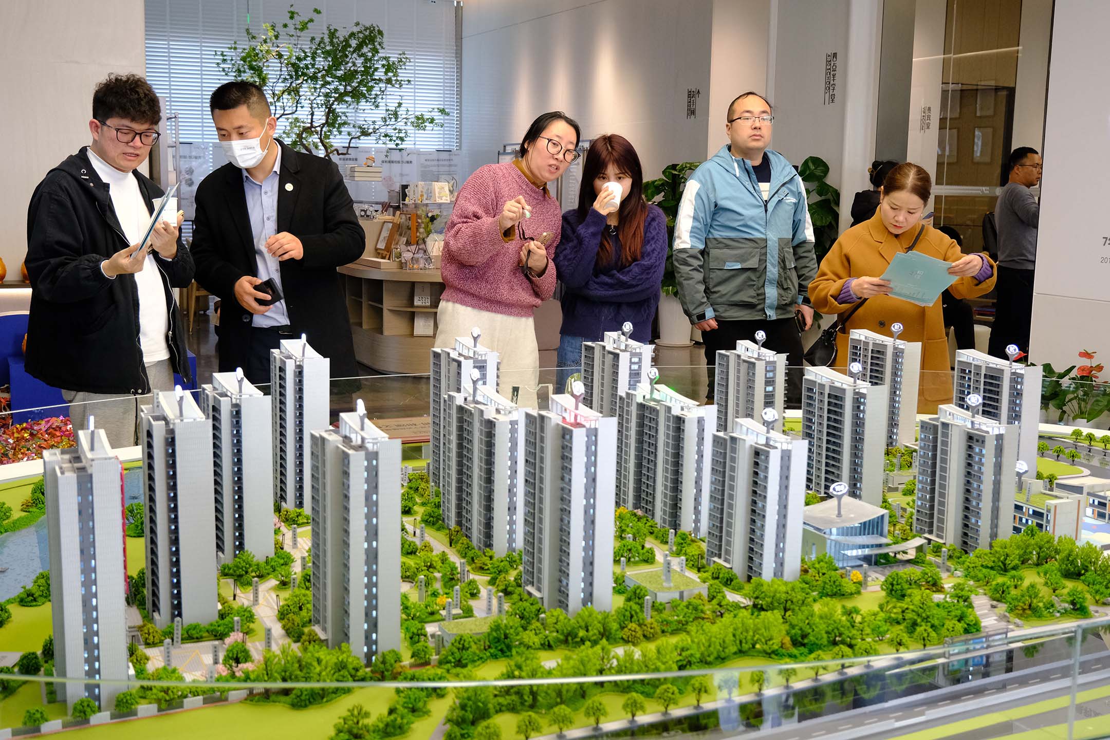 2023年3月4日，中國浙江省寧波市，人們在銷售處觀看住宅建築模型。攝：VCG/VCG via Getty Images