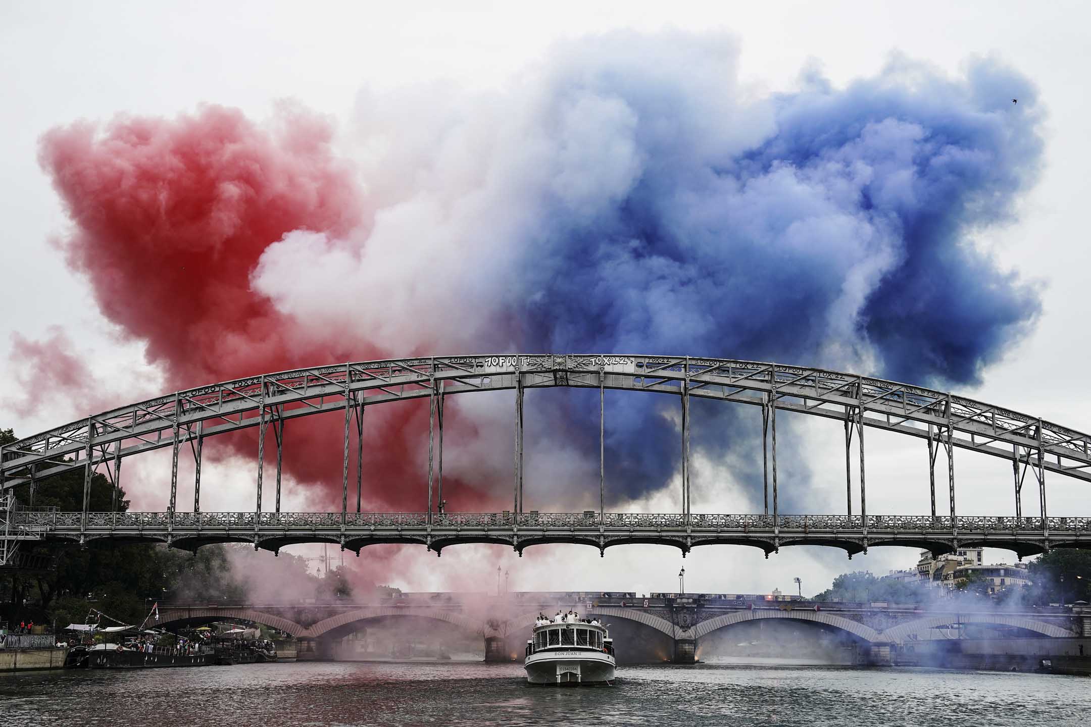 2024年7月26日,河上的桥喷出红白蓝法国国旗的颜色。摄:David Burnett/IOC via Getty Images