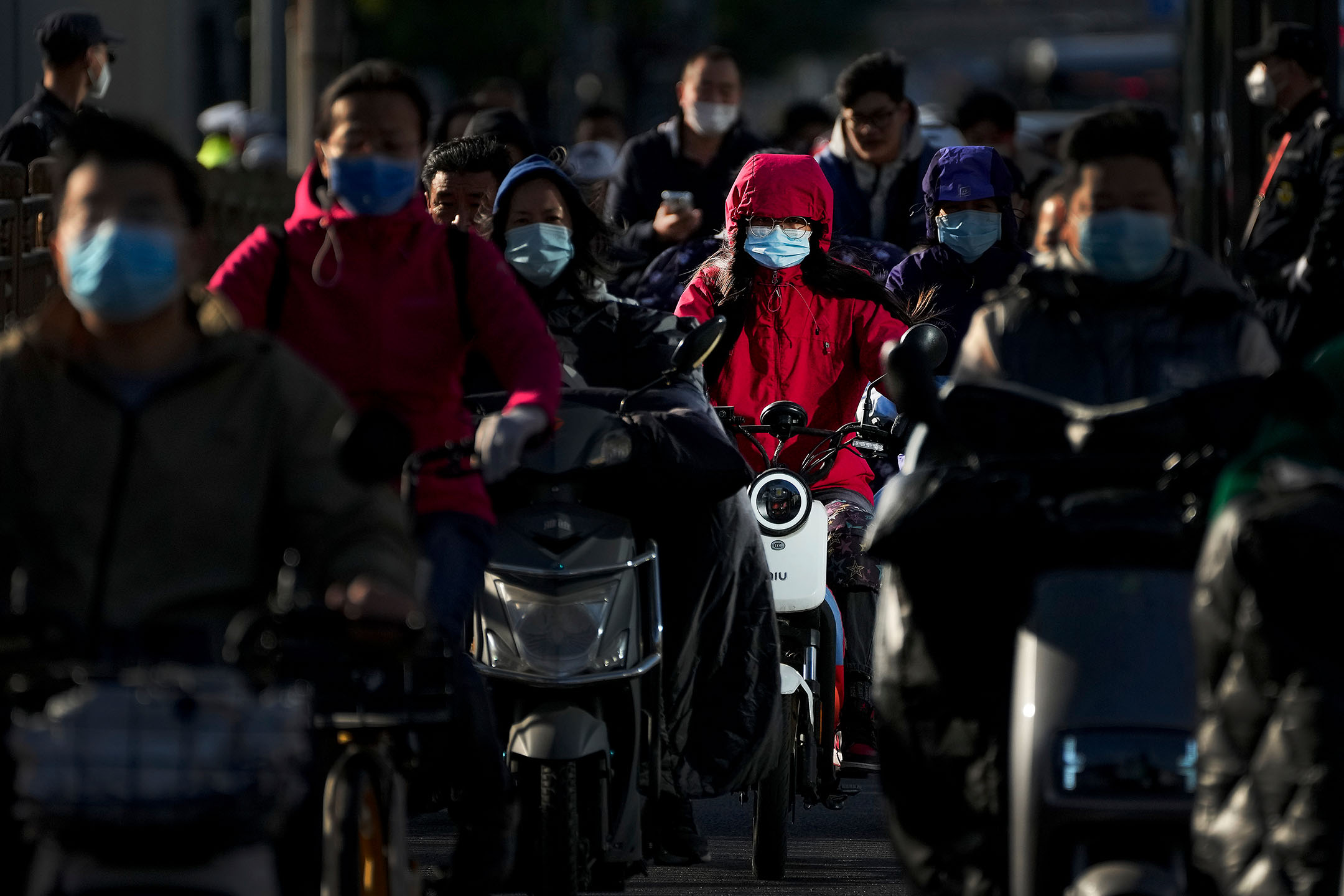 2022年10月16日,中國北京,人們在街上騎着電動車。攝:Andy Wong/AP/達志影像