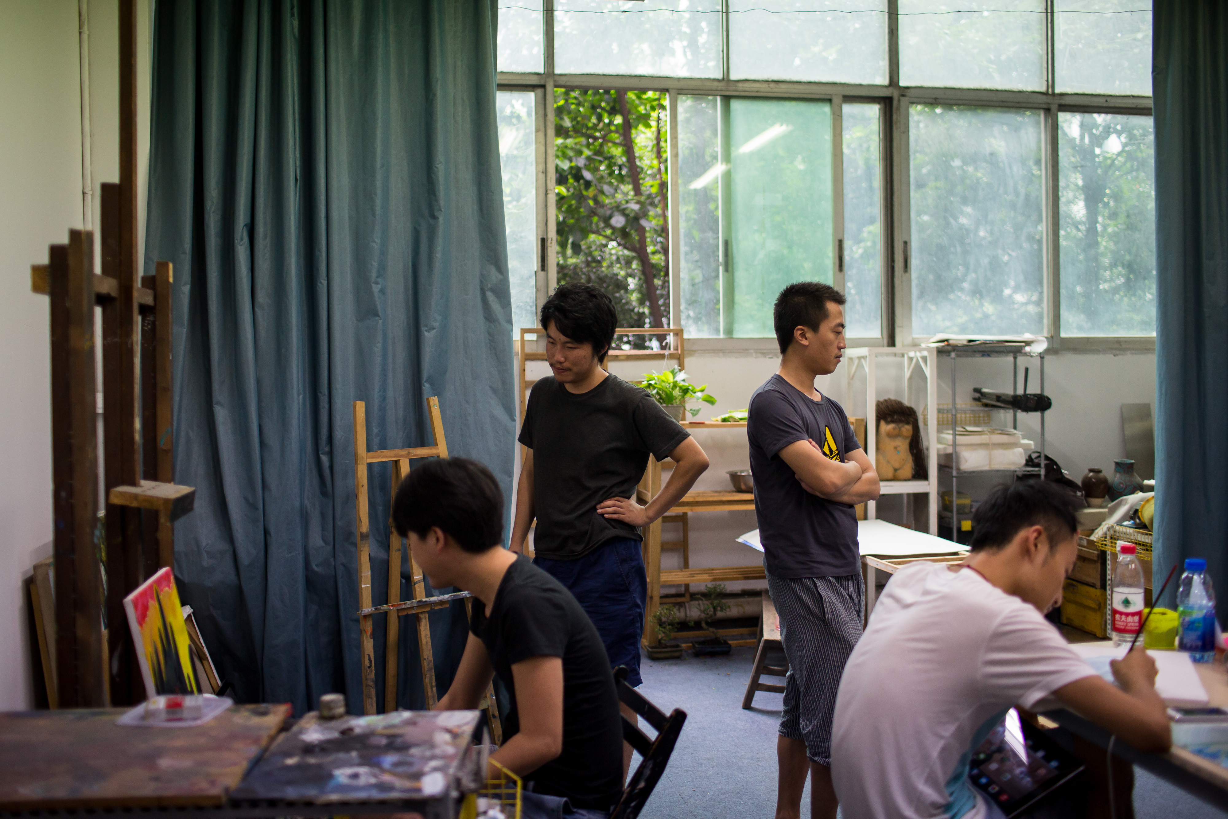 刘伟伟(左二)在朋友的油画工作室。摄: Billy H.C. Kwok/ 端传媒