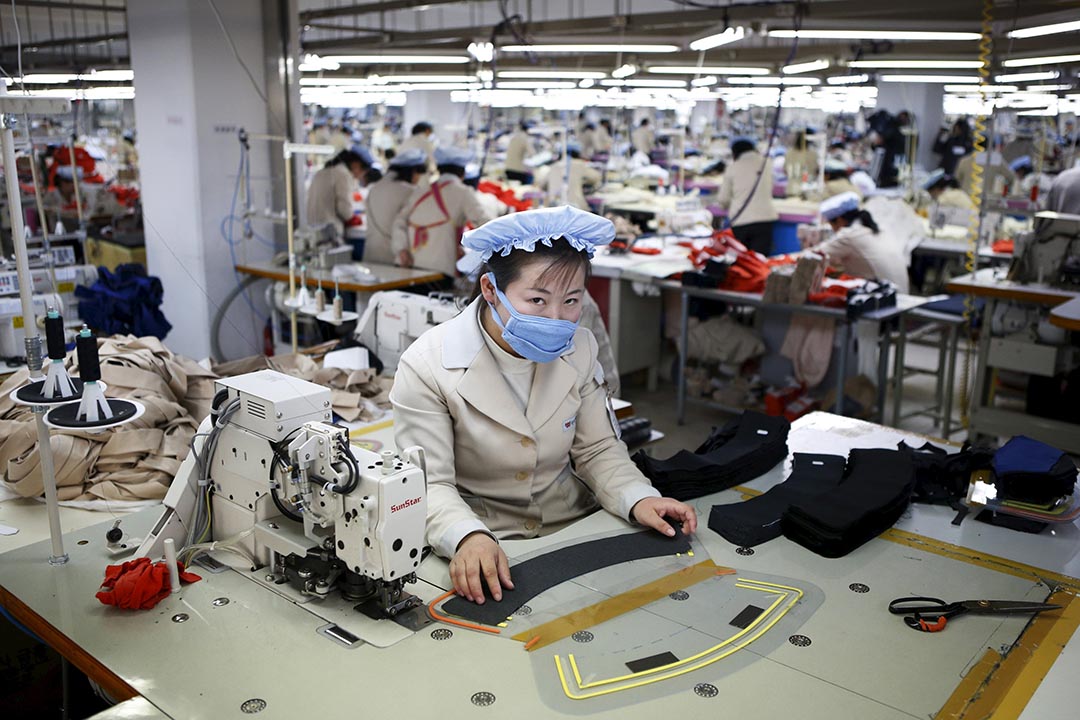 开城工业园区一间工厂一名女工在工作。摄:Kim Hong-Ji/REUTERS
