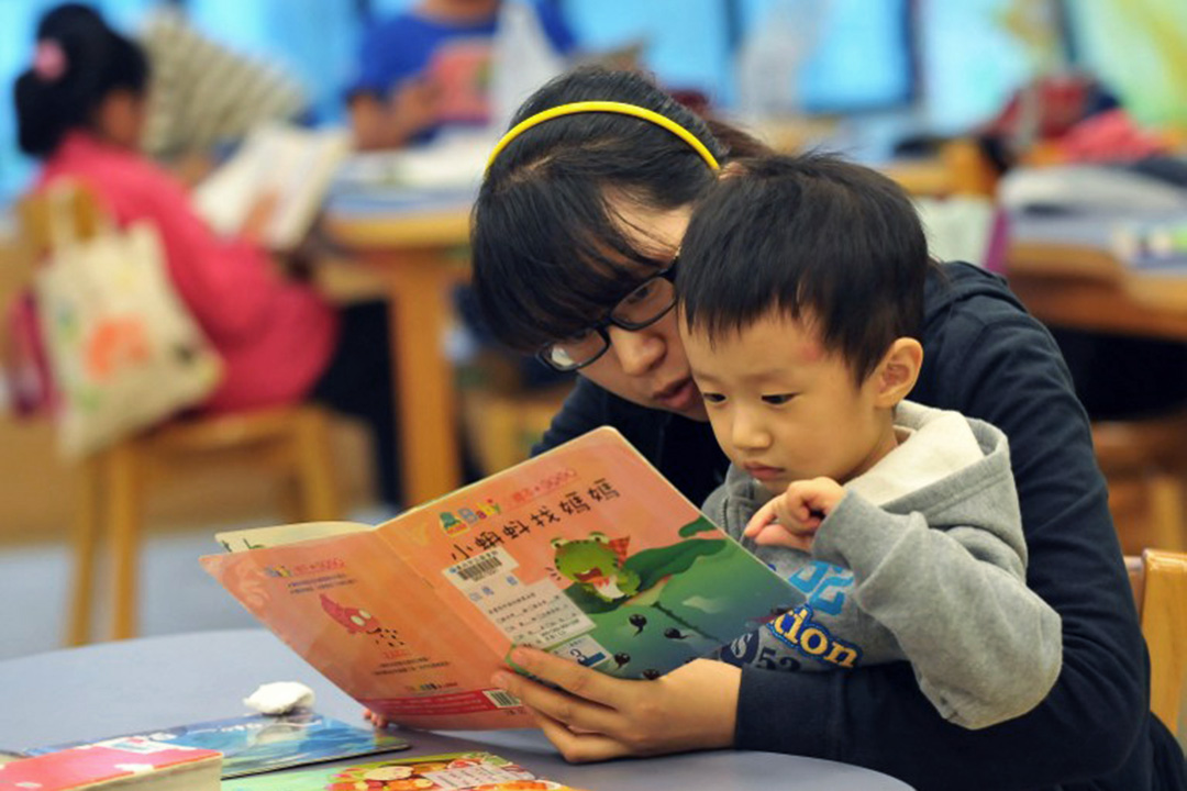 圖為一名母親與孩子在台北國立圖書館閱讀圖書。攝：Mandy Cheng/AFP