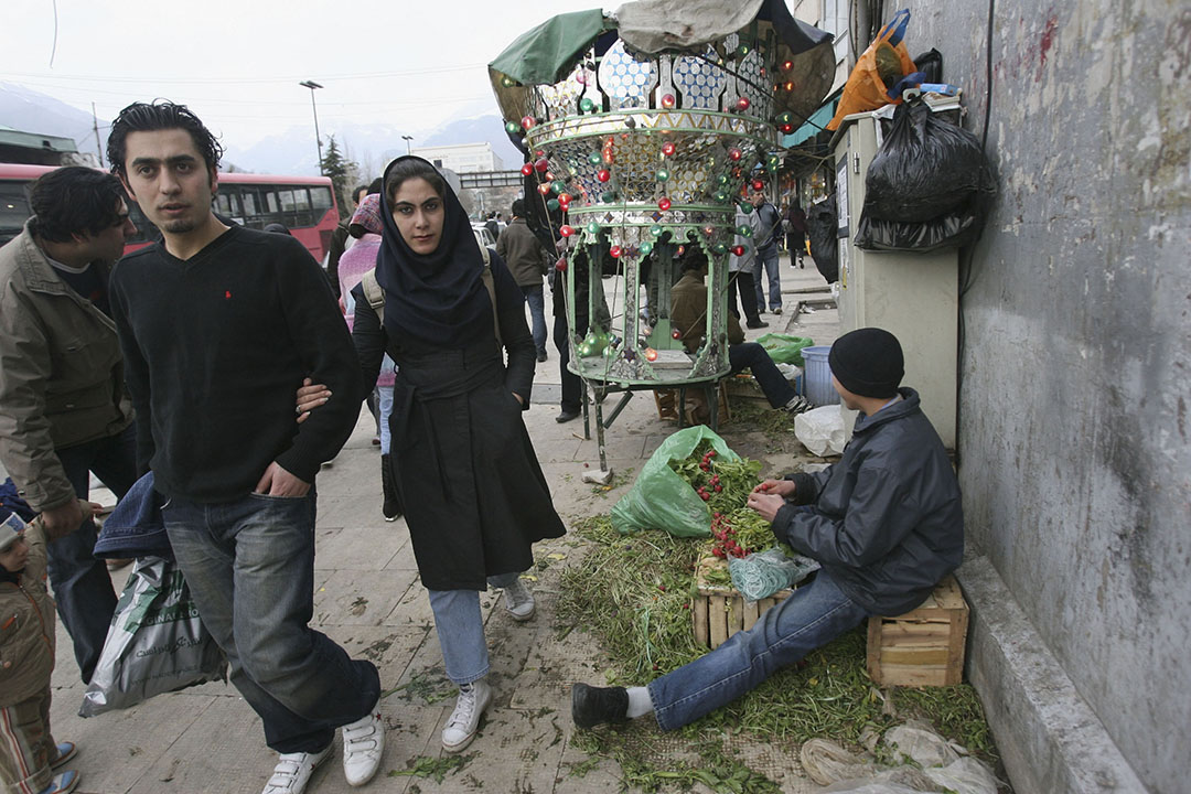 一對情侶在伊朗德克蘭逛街，路邊有擺檔的小販。攝：Majid Saeedi/GETTY