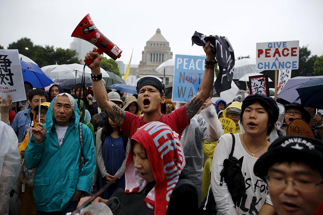 示威者在国会大楼前抗议,反对首相安倍晋三推动的安保法案。 摄 : Thomas Peter/REUTERS